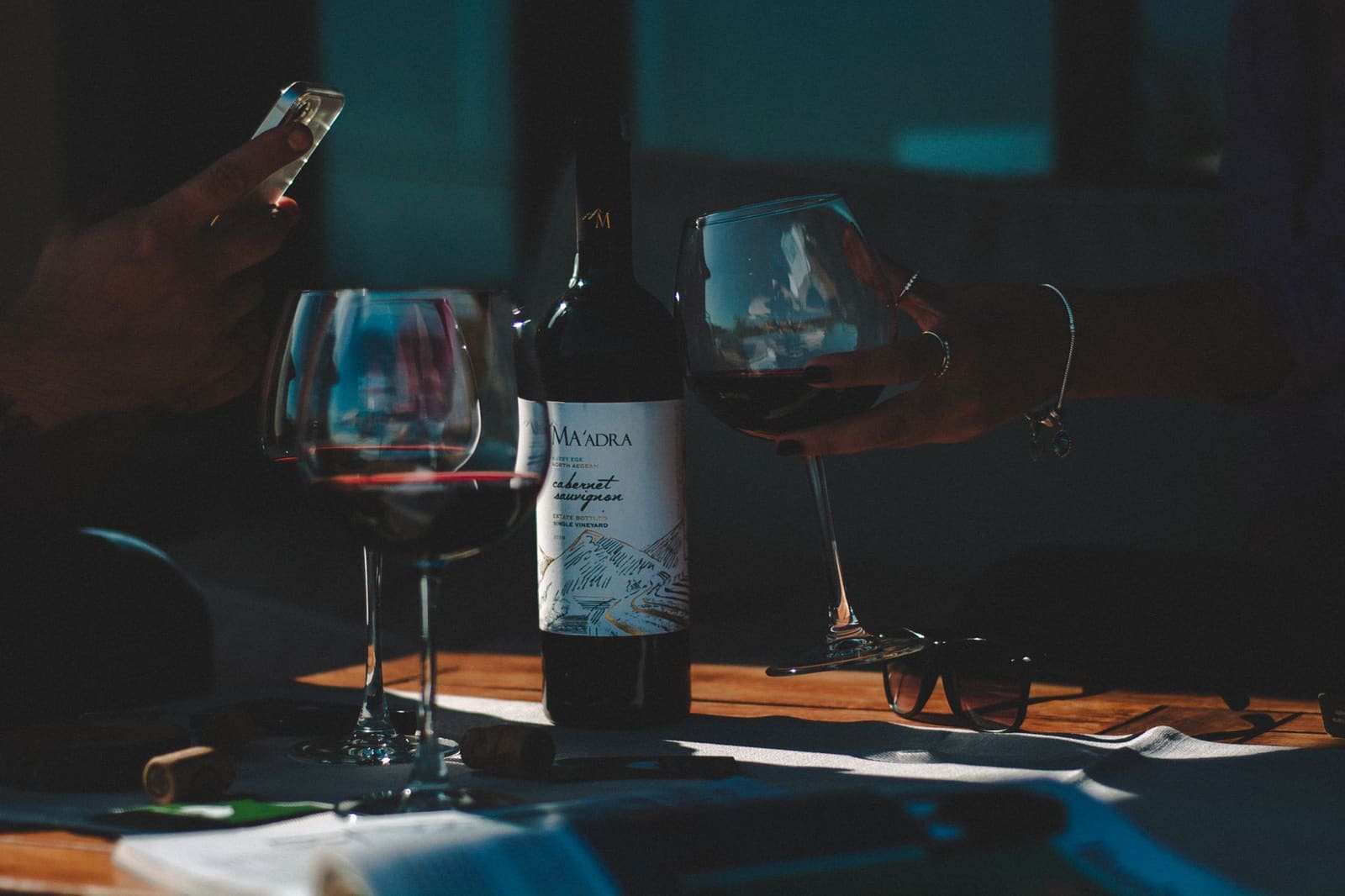 Een glas rode cabernet sauvignon wijn met flessen op de achtergrond in een restaurant