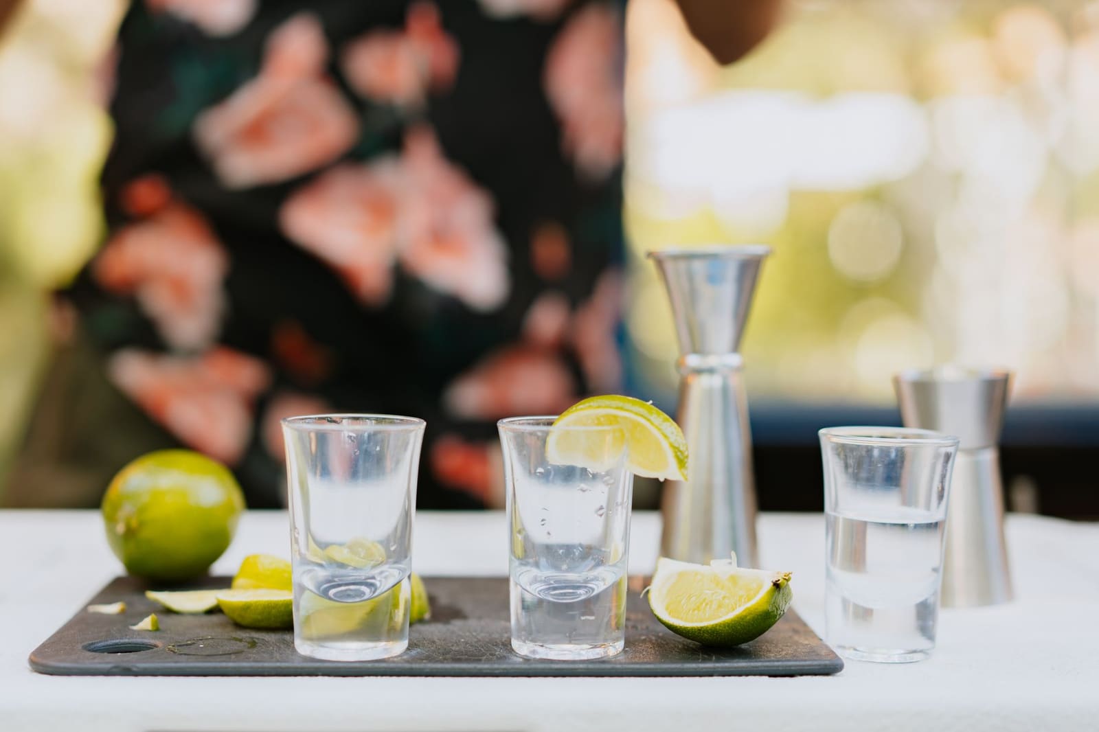 Cocktailglas met tequila en ijs op een houten terrastafel buiten
