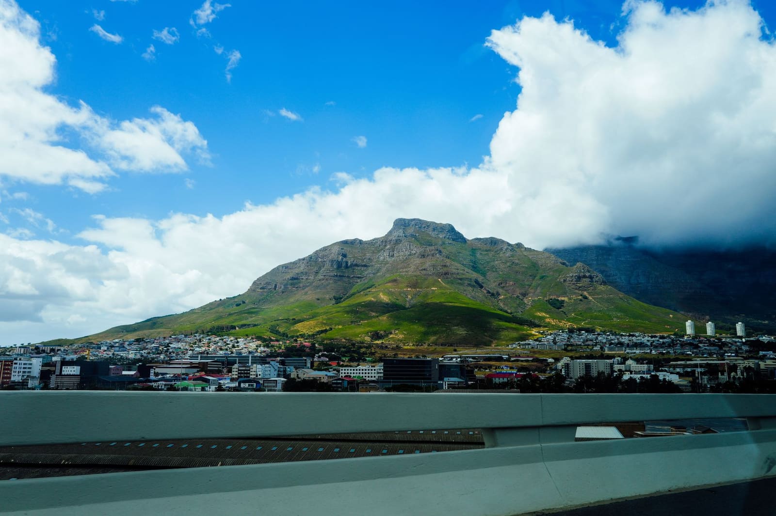 Stadsgezicht van Kaapstad met een tafelberg op de achtergrond bij zonsondergang.