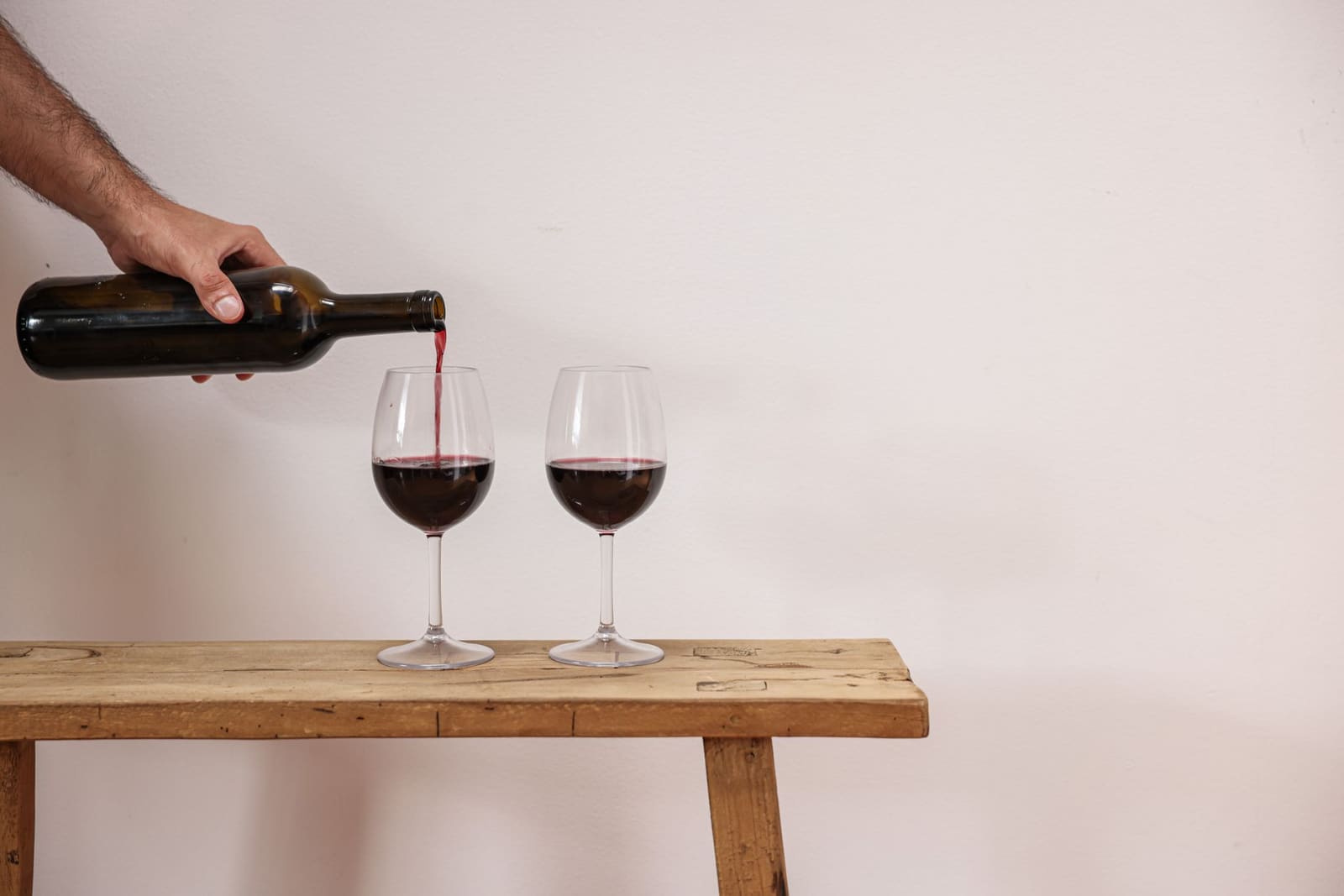 Fles alcoholvrije wijn met een gevuld glas op een tafel