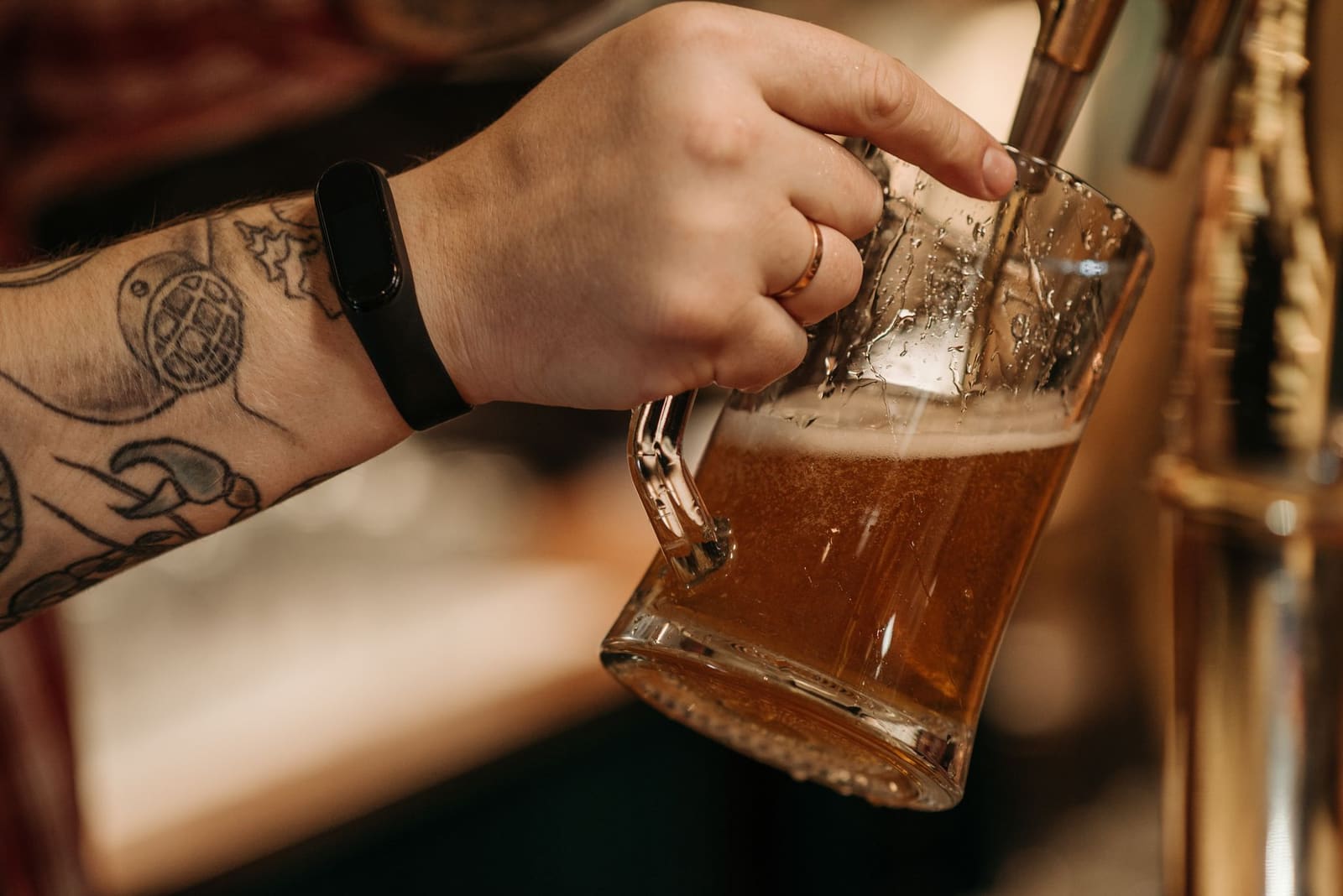 Glas amberkleurig alcoholvrij Oktoberfestbier met een schuimkraag op een houten bar