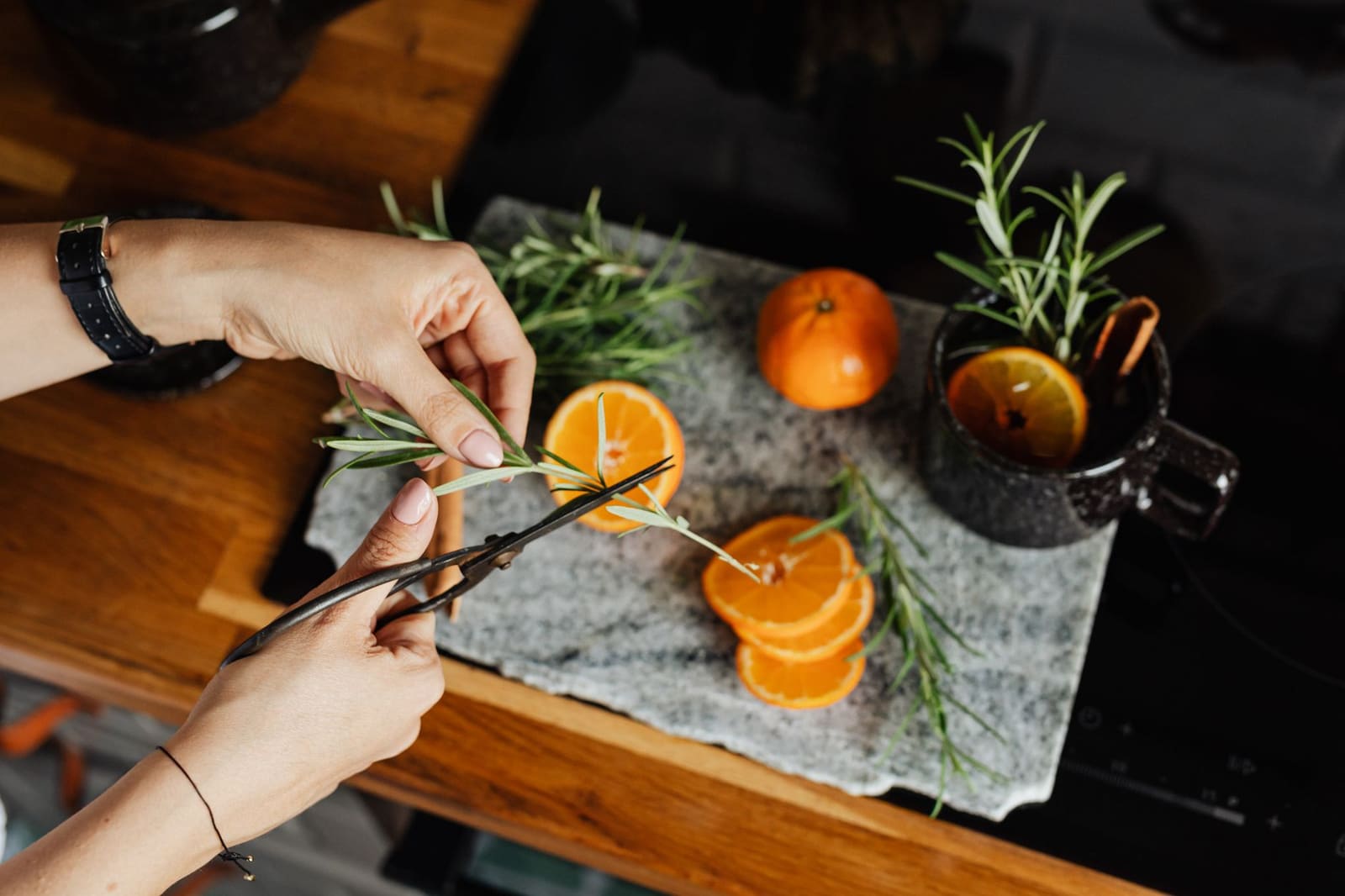 Verse citrus, rozemarijn en kruiden liggen klaar voor een alcoholvrije cocktail op de bar.
