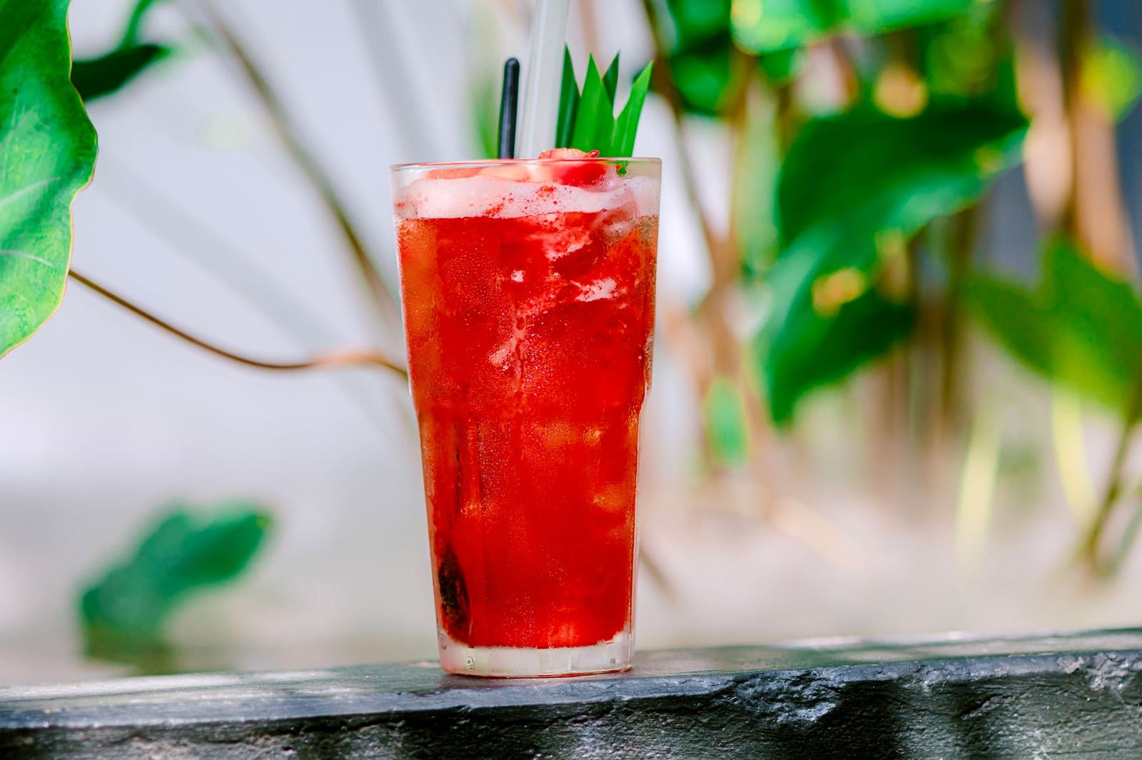 Frisse mocktail met munt en limoen in een hoog glas met rietje.