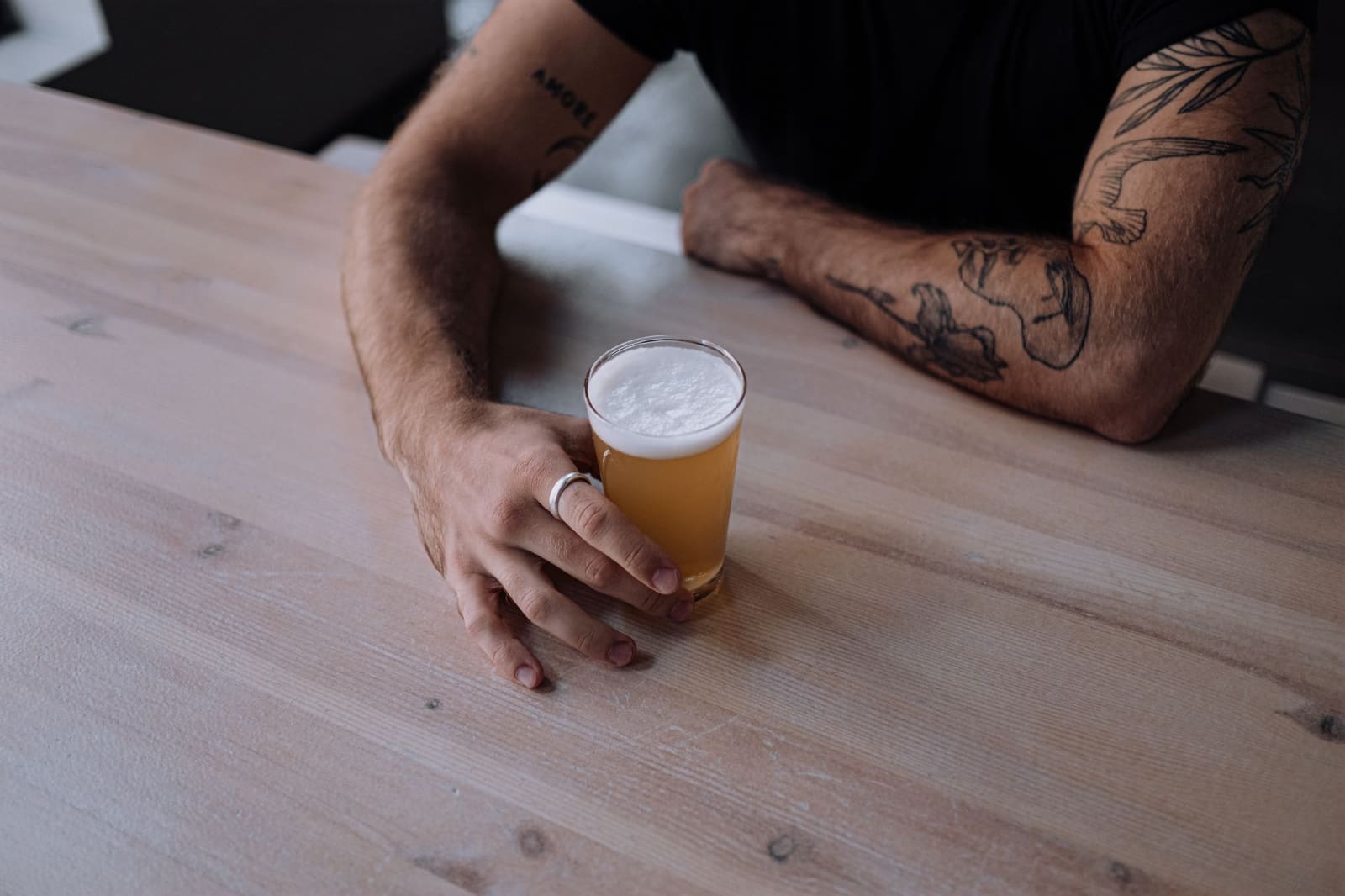 Glas ambachtelijk bier met schuimkraag op een houten tafel