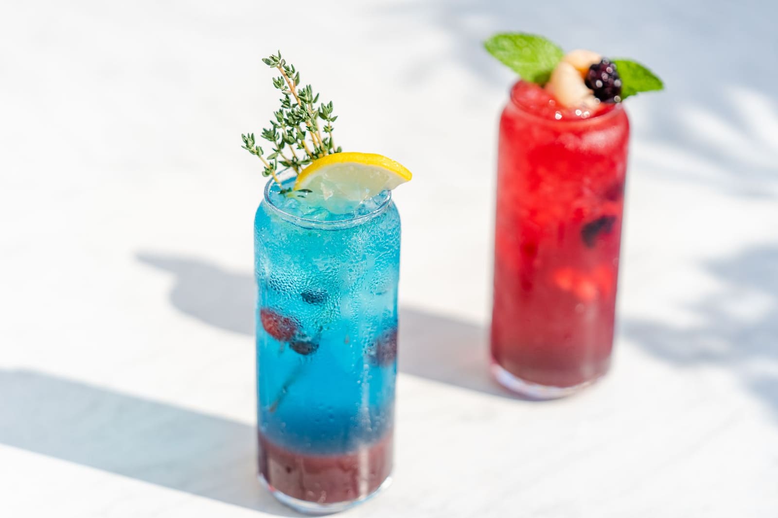 Felgekleurde blauwe cocktail met een opvallende garnering geserveerd