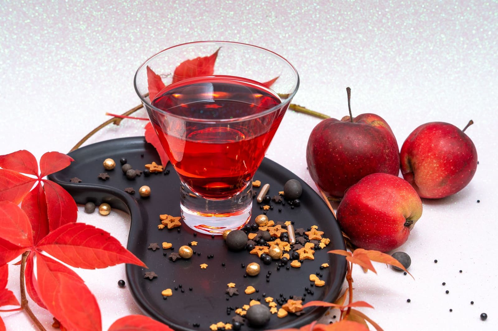 Glas met appelcider cocktail en kaneelstokje op een houten bar in herfstsfeer