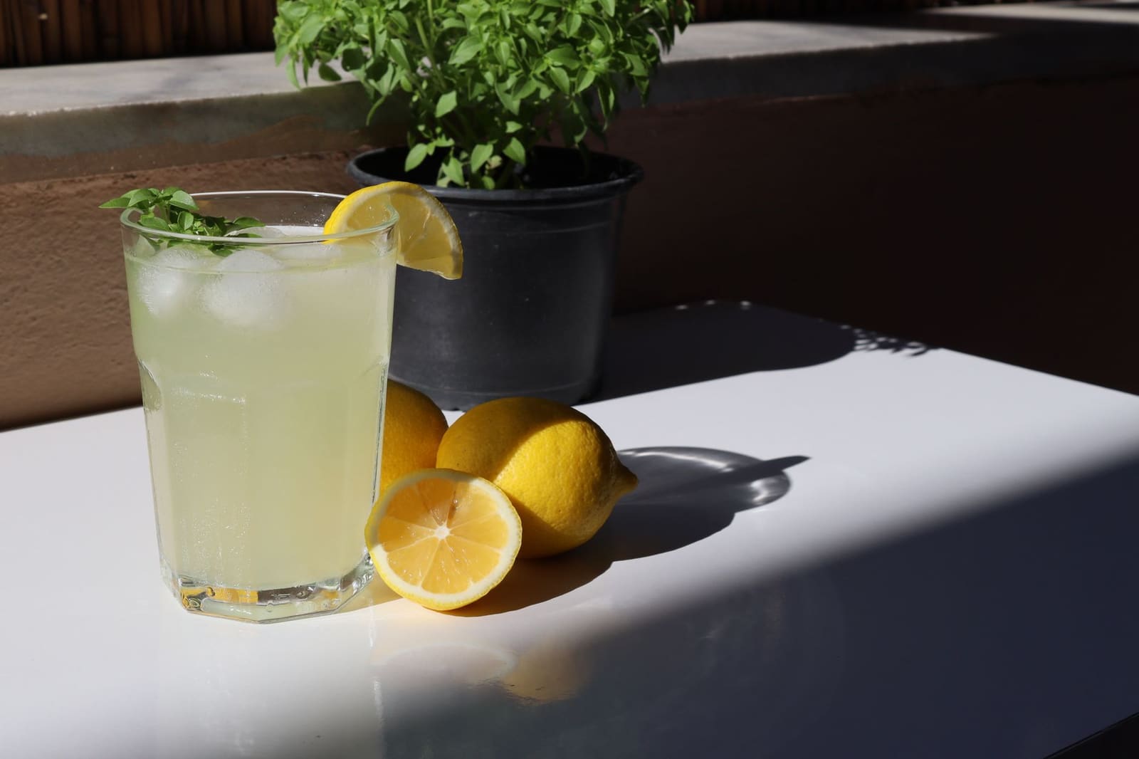 Glas verse limonade met citroen en muntblaadjes op een tafel