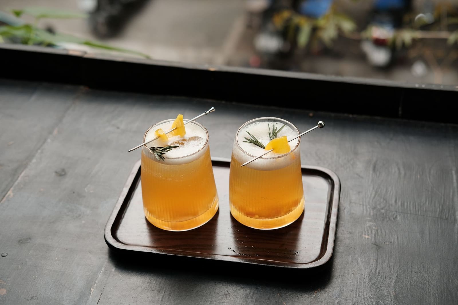 Close-up van een gestileerde cocktail met garnering op een bar