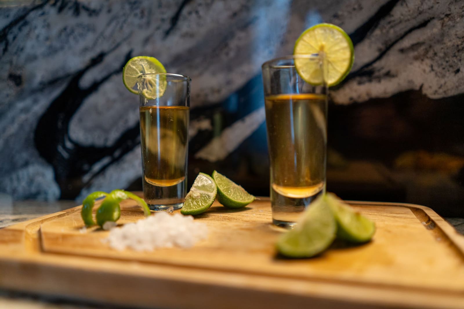 Glaasje tequila naast een schijfje limoen en een snuifje zout