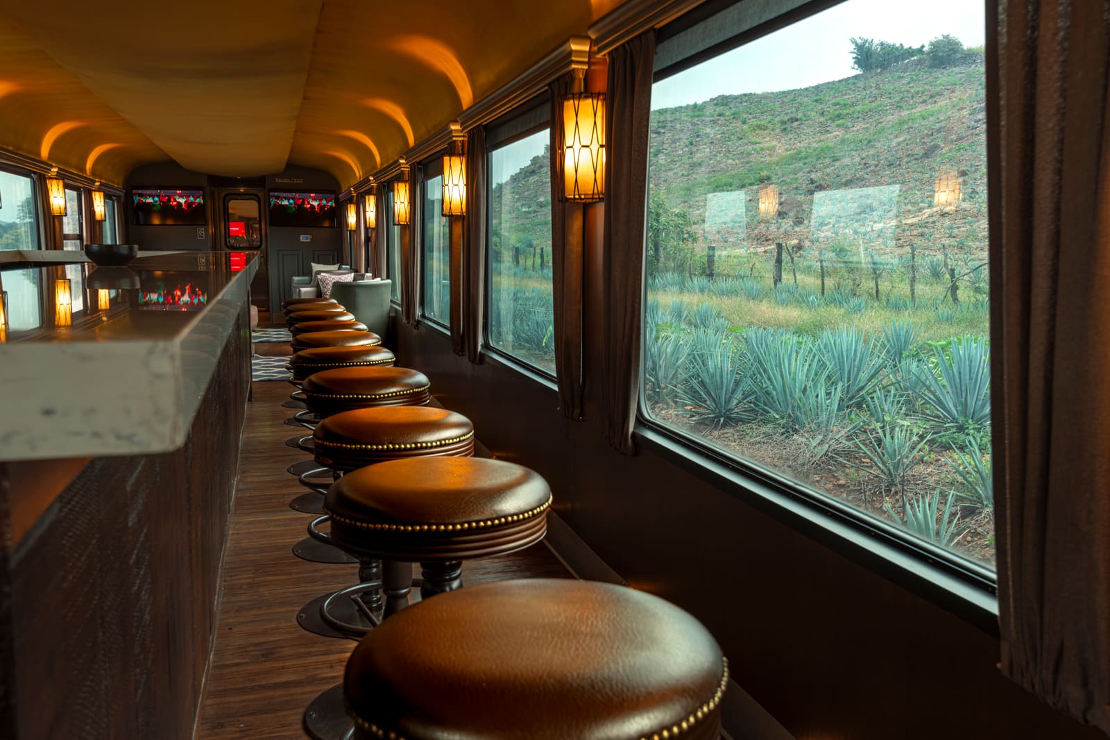Interieur van een tequilabar met houten kasten vol flessen en warme verlichting
