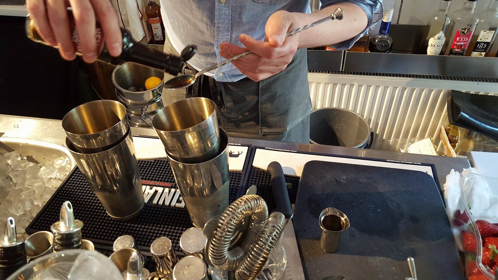 Bartender bereidt een cocktail met drie ingrediënten tijdens een competitie achter de bar