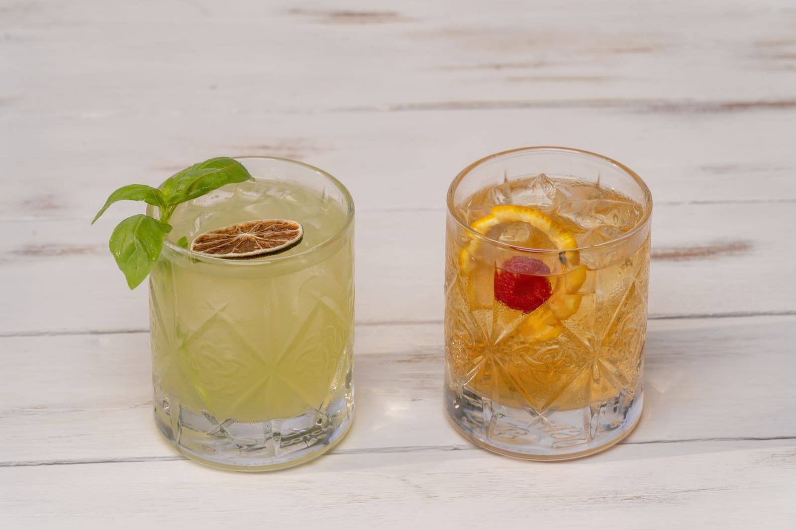 Diverse cocktailingrediënten zoals bitters, siroop en citrus op een houten bar