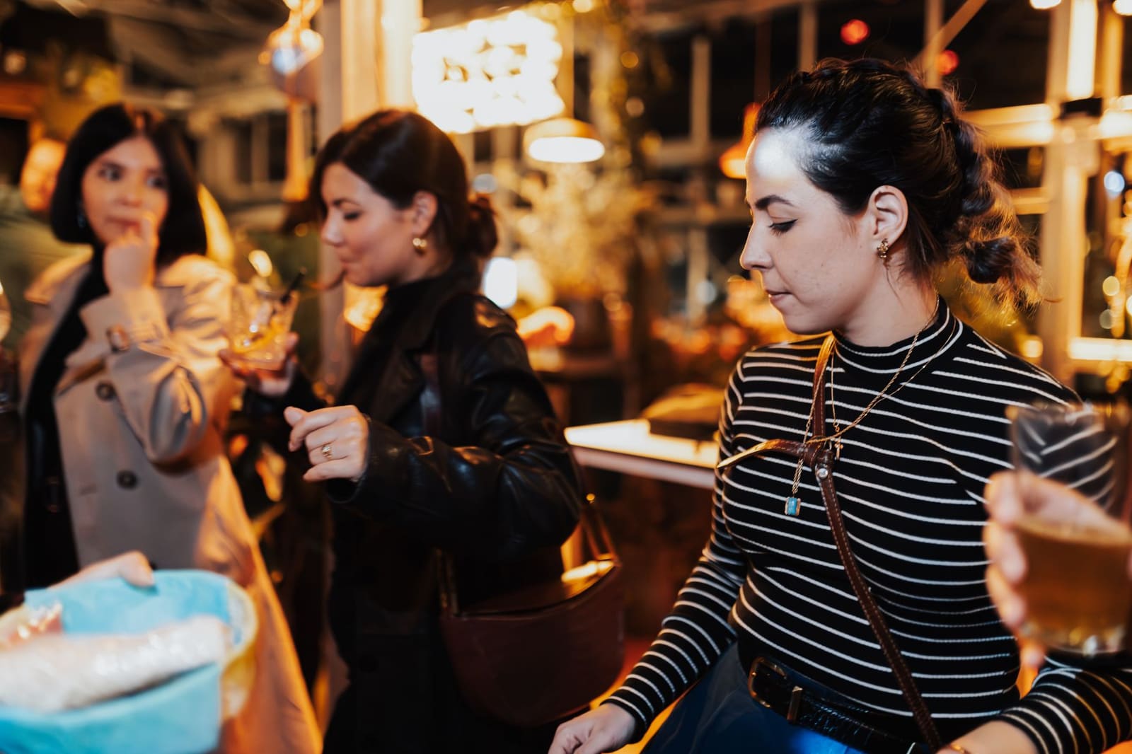 Gasten kijken toe terwijl een bartender hen leert een cocktail te maken tijdens een feestje