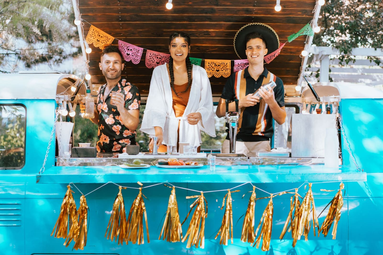 Een mobiele cocktailbar met glazen en flessen op een feestlocatie in de avond