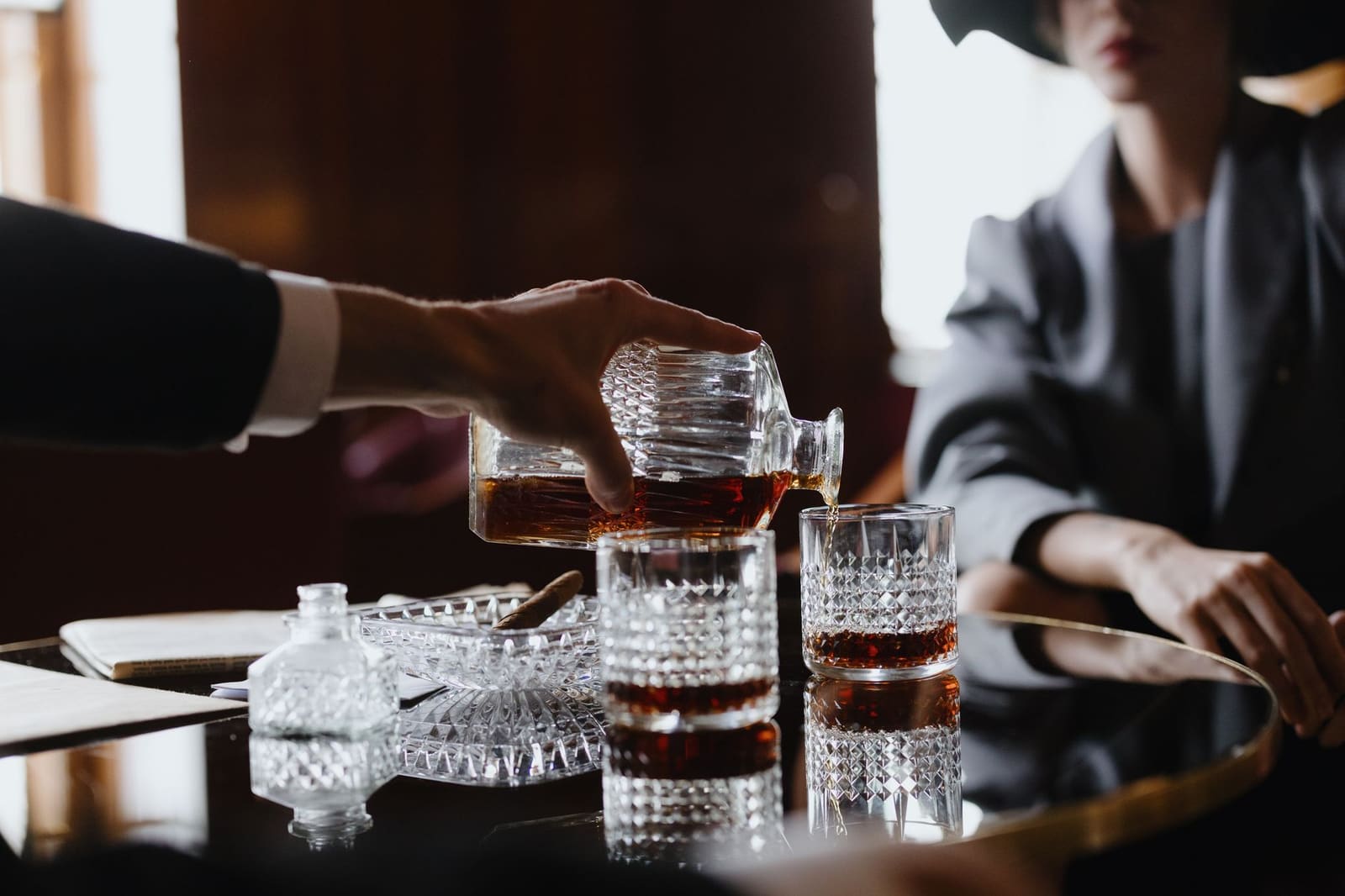 Cognac wordt uitgeschonken uit een fles voor het bereiden van een cocktail