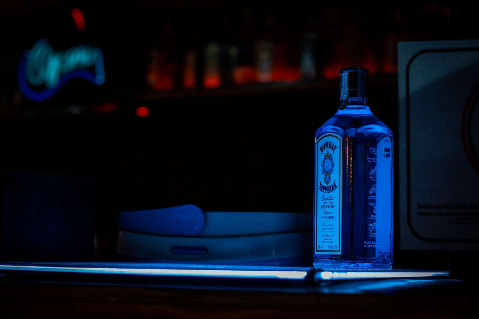Fles gin op de bar naast citrusvruchten en ijsblokjes