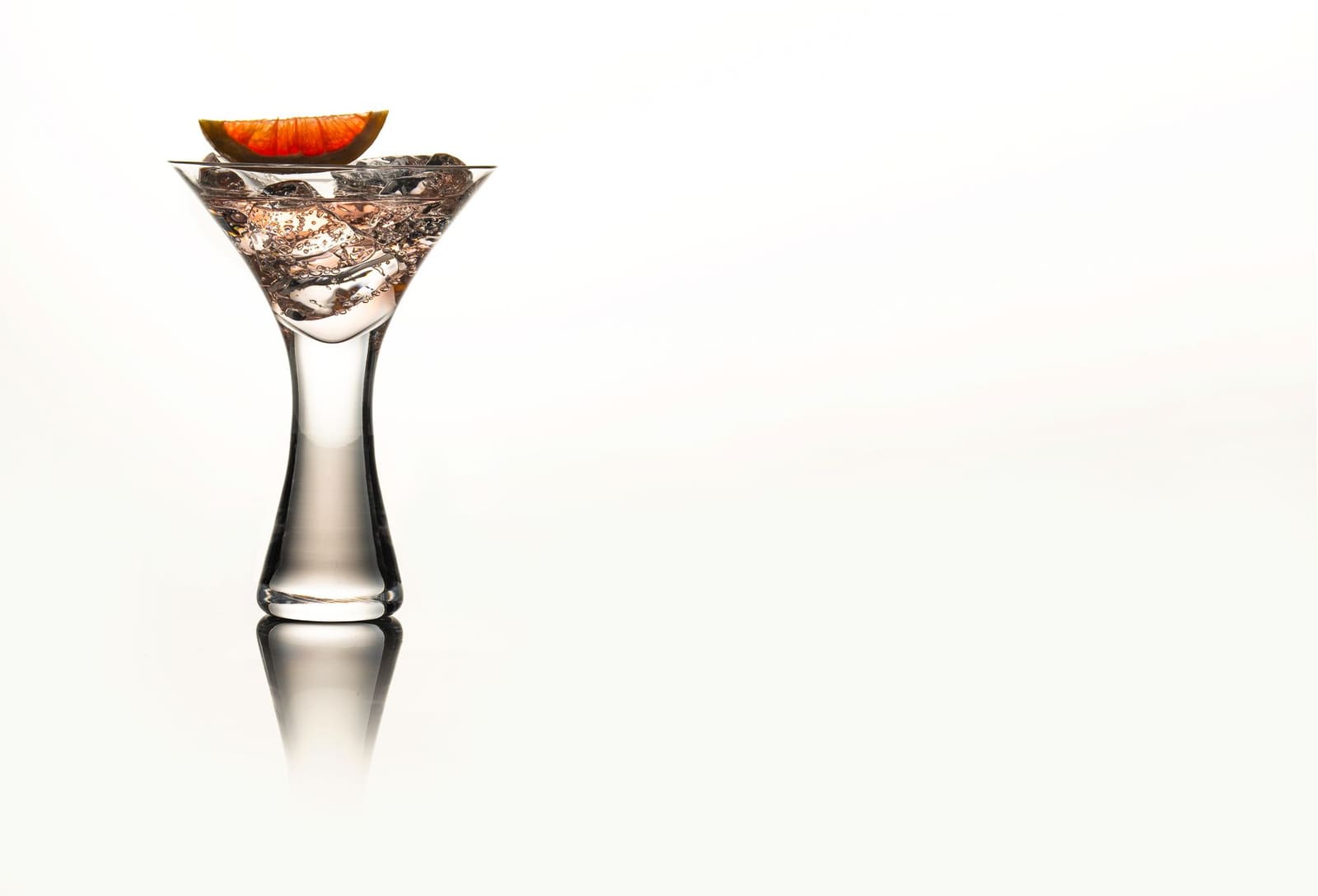 Gimlet cocktail met bloedsinaasappel en een gedroogde sinaasappelschijf als garnish