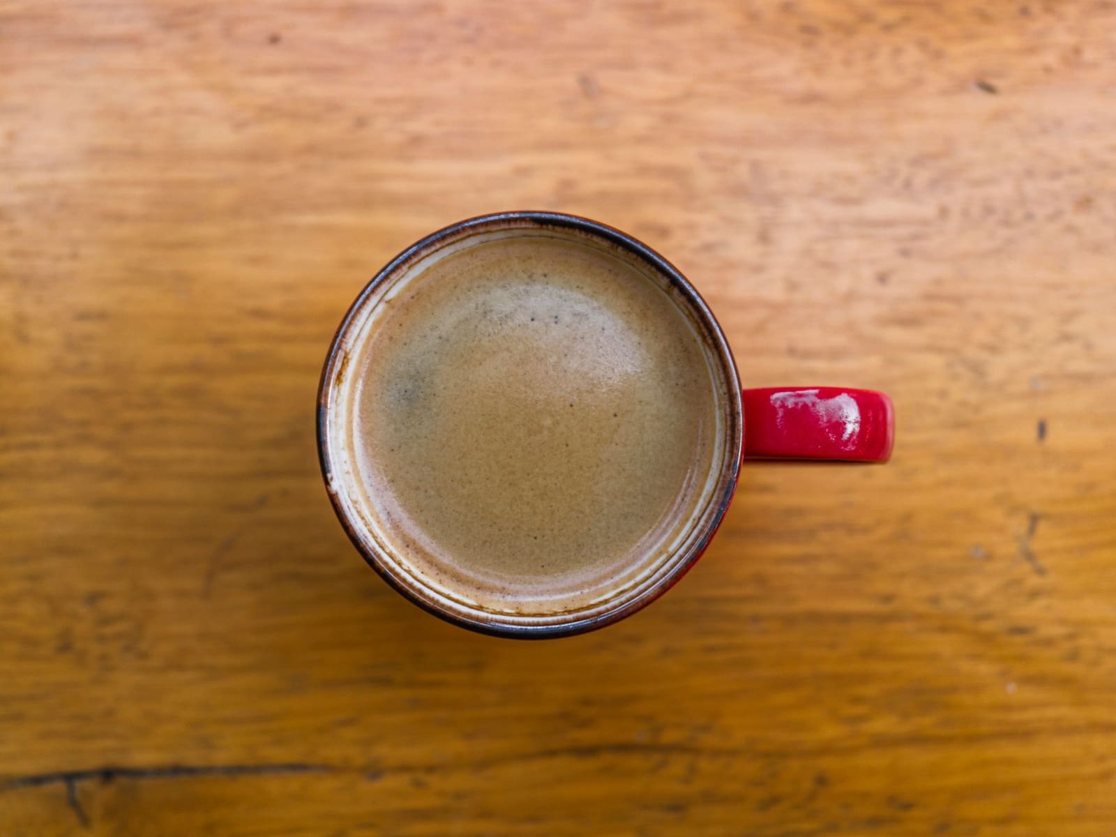 Close-up van een kopje zwarte koffie op een houten tafel