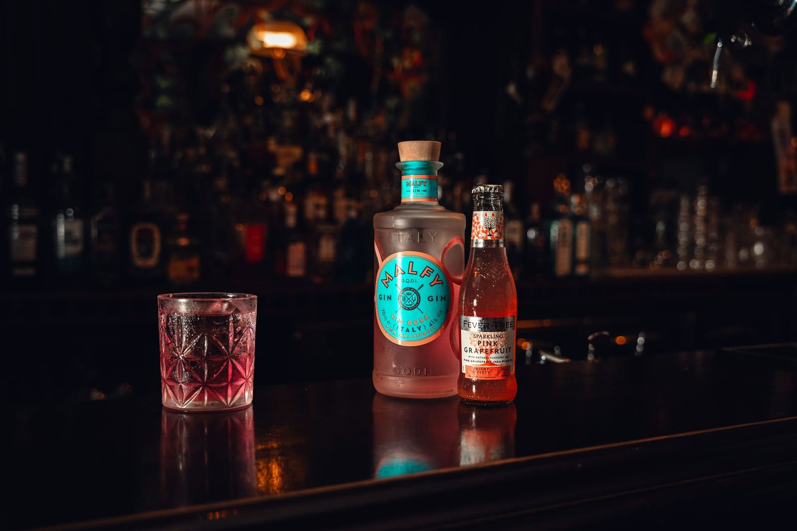 Flessen gin op een planken in een bar