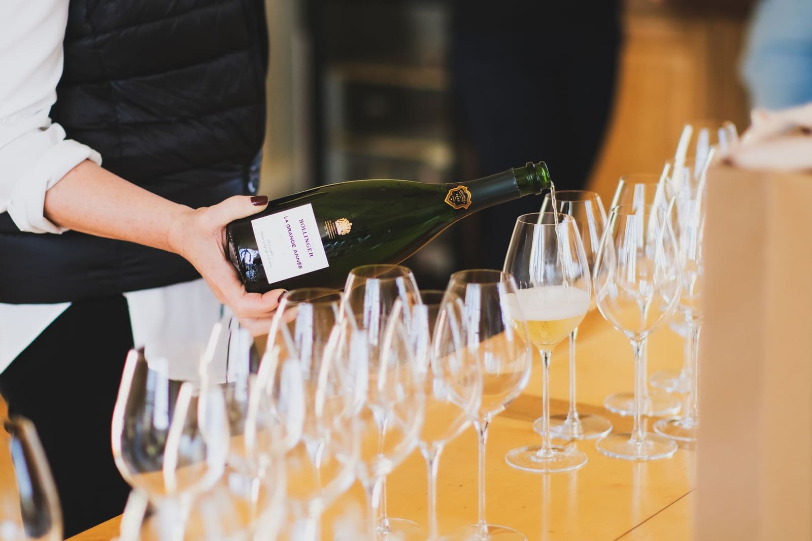 Fles champagne wordt ingeschonken in een glas op een tafel