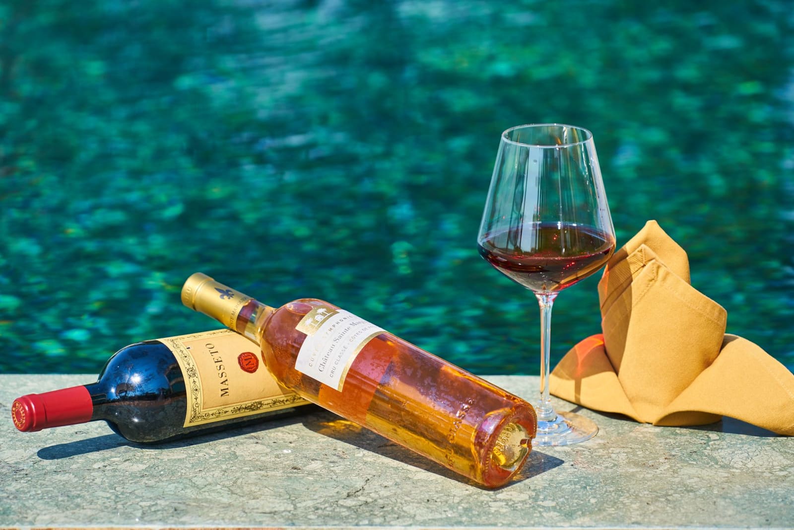 Fles rode wijn met condensdruppels op een zomerse buitentafel