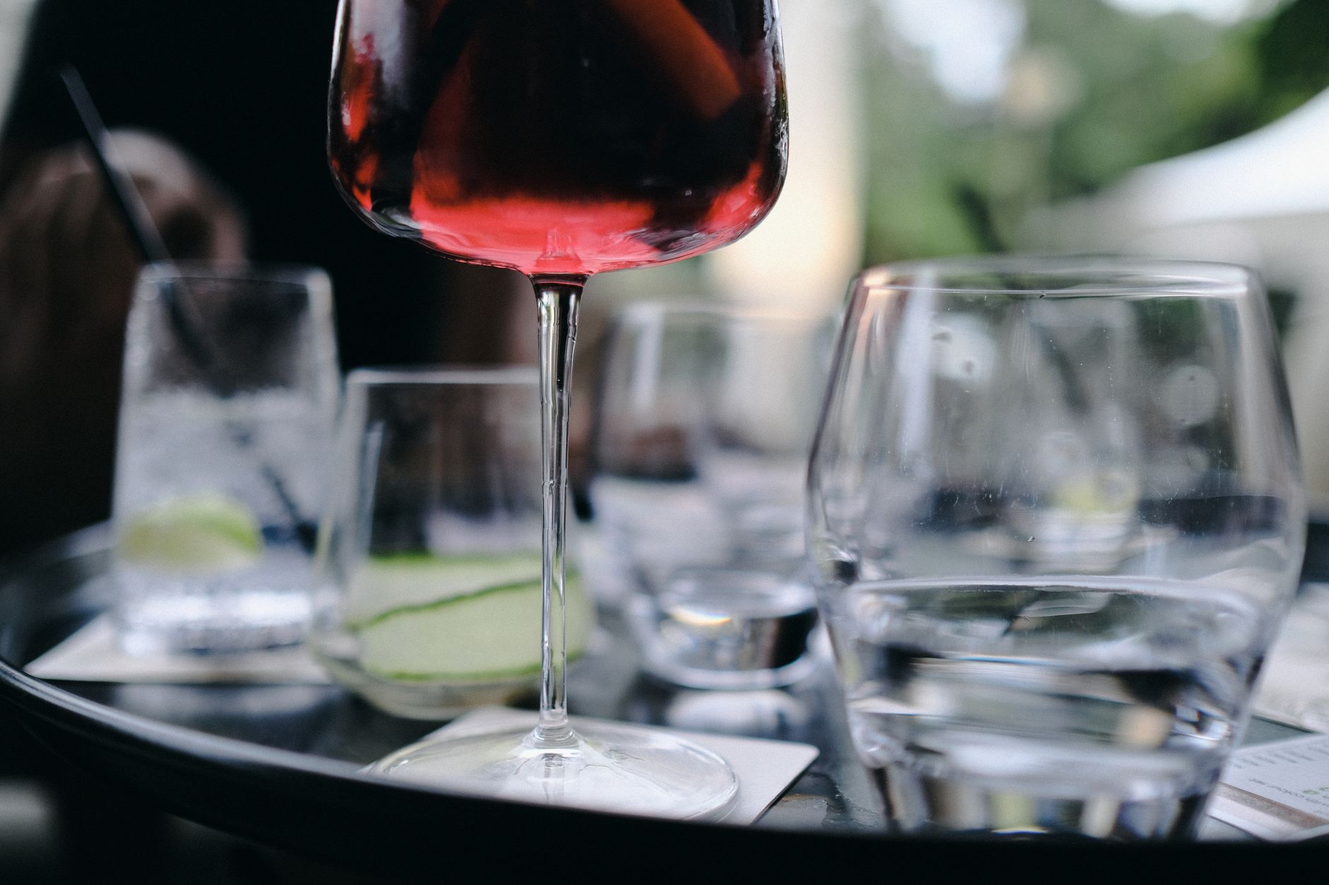 Glas gekoelde rode wijn met ijsblokjes op een zomerse tafel buiten