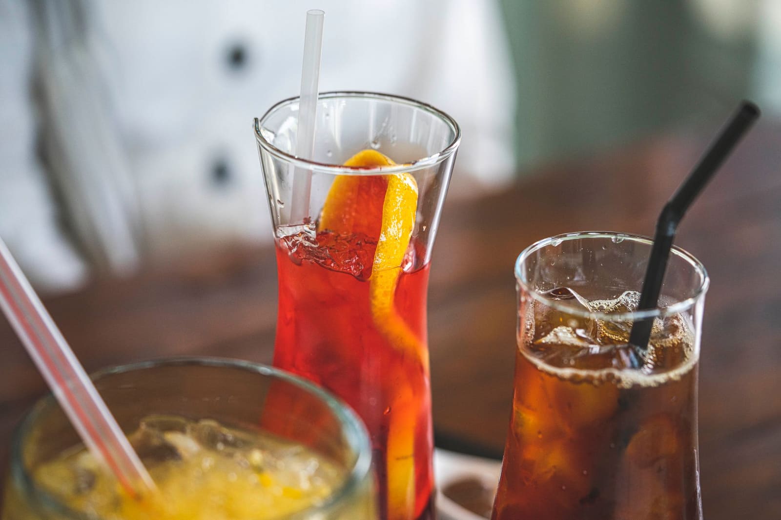 Een glas Aperol Spritz met ijs en een schijf sinaasappel op een tafel.