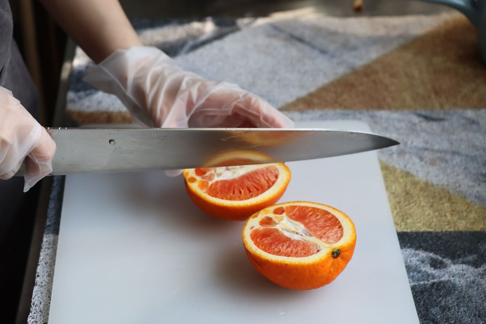 Handen van een bartender die met een klein mes een citroen snijden op een werkblad in de bar