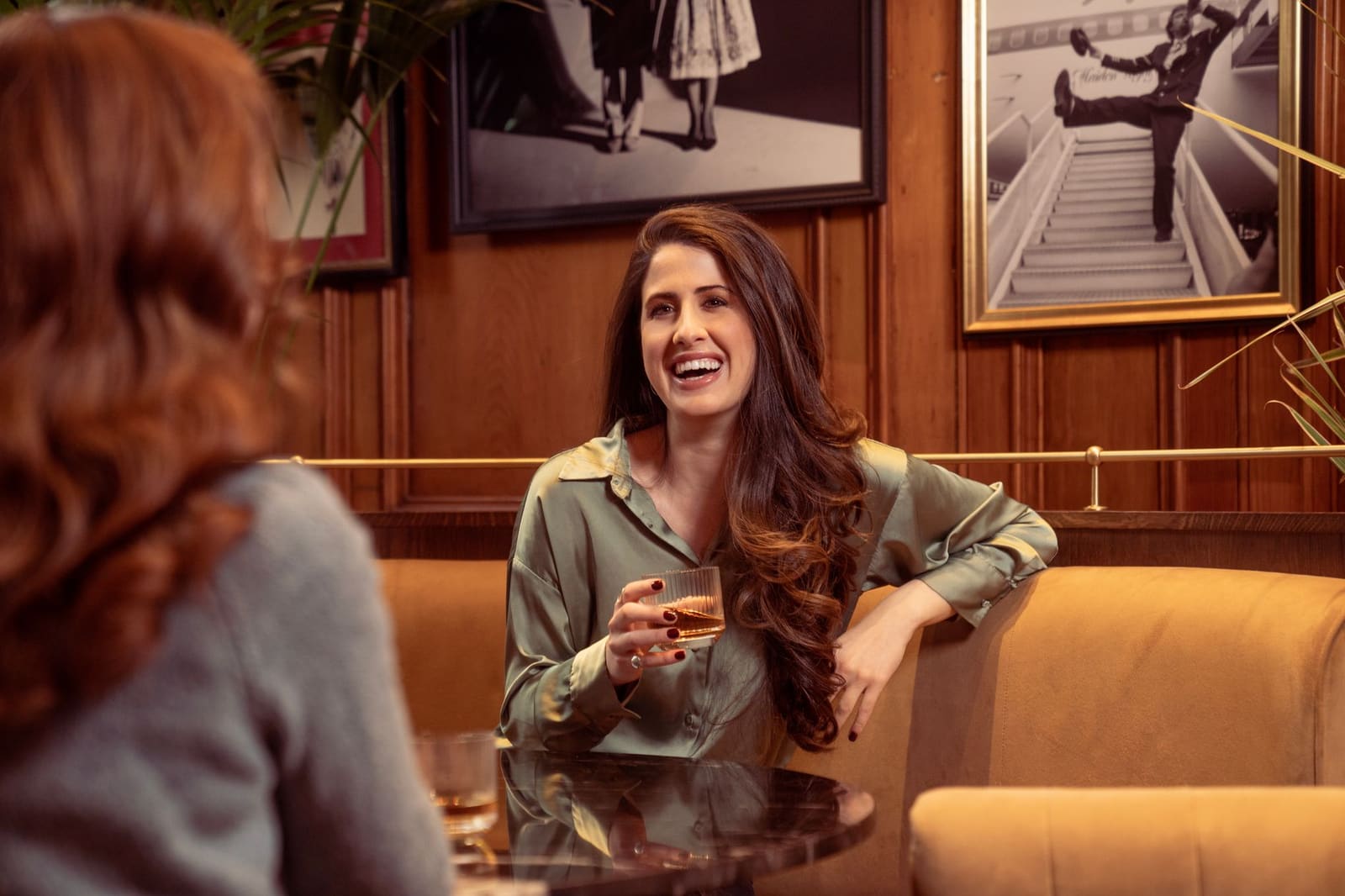 Publiek staat met glazen whisky in een zaal tijdens een proeverij