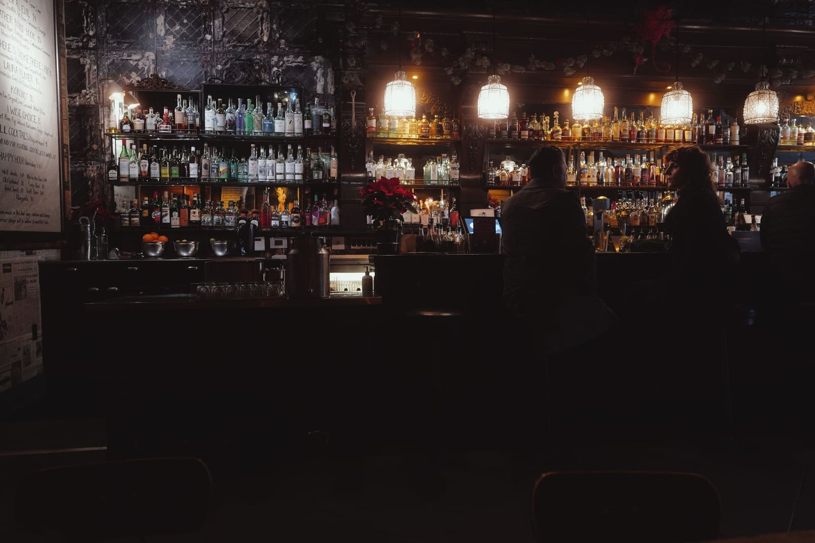 Sfeervol verlicht bar-interieur waar bezoekers genieten van cocktails tijdens een festivalavond