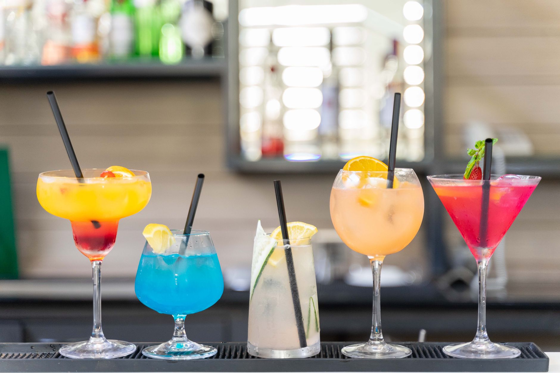 Verschillende cocktails naast elkaar op een bar