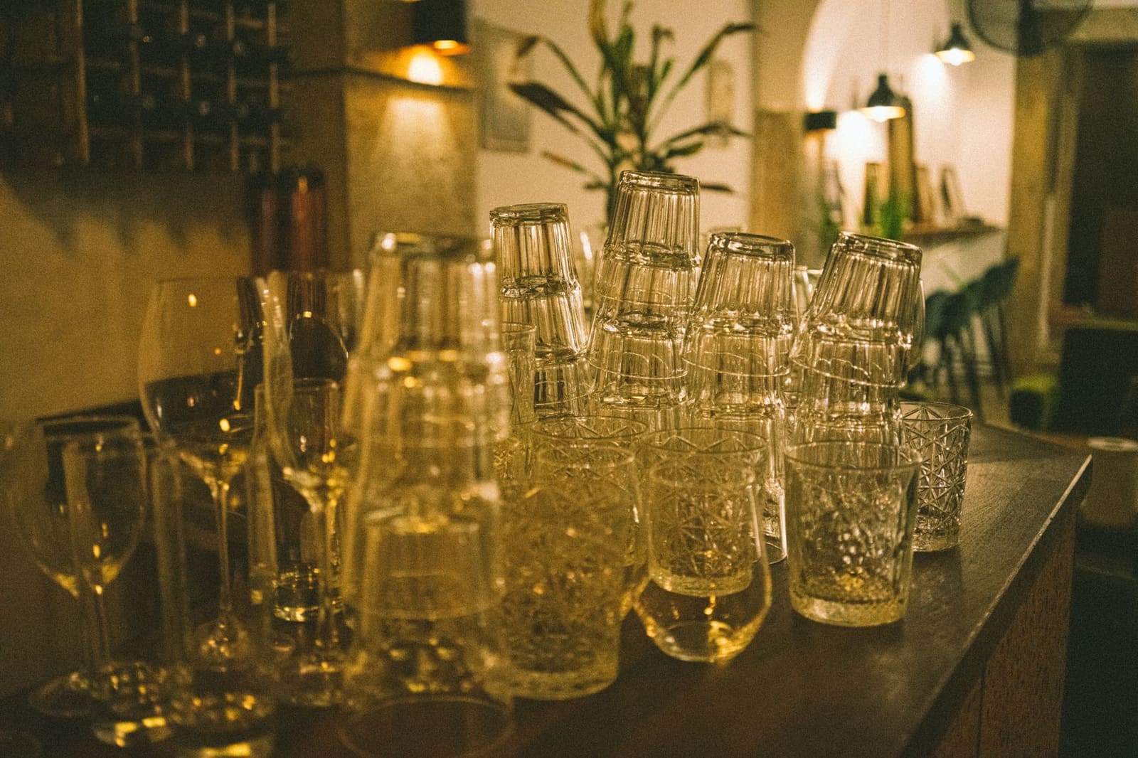 Gevulde cocktailglazen op een houten barbank, met citrusschillen en een takje munt als garnish