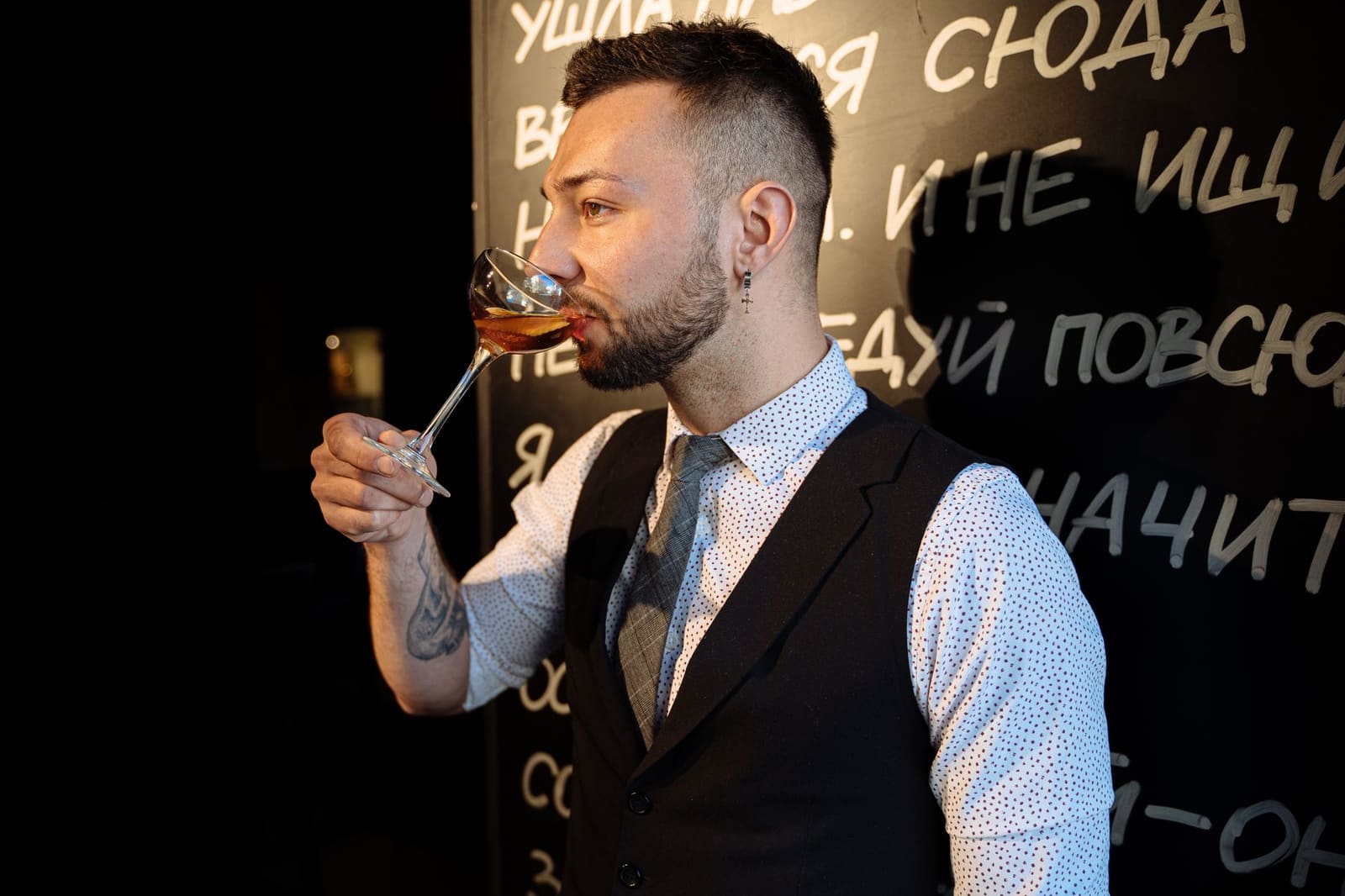 Gasten proeven cocktails tijdens een avond in een bar met verlichting en lange tafels