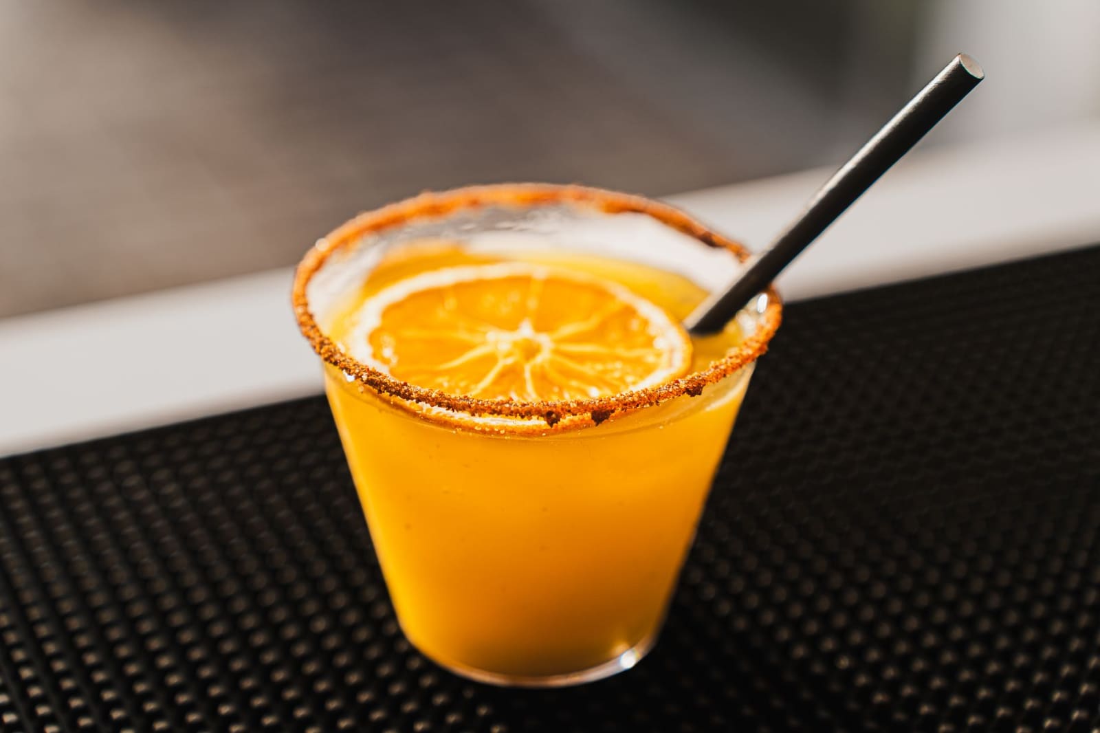 Gevulde cocktailglazen met een schilletje citrus als garnering op een donkere bar