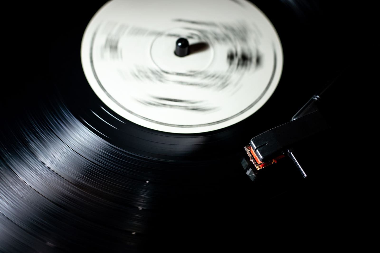 Een draaitafel met een vinylplaat die langzaam draait op een donkere tafel.