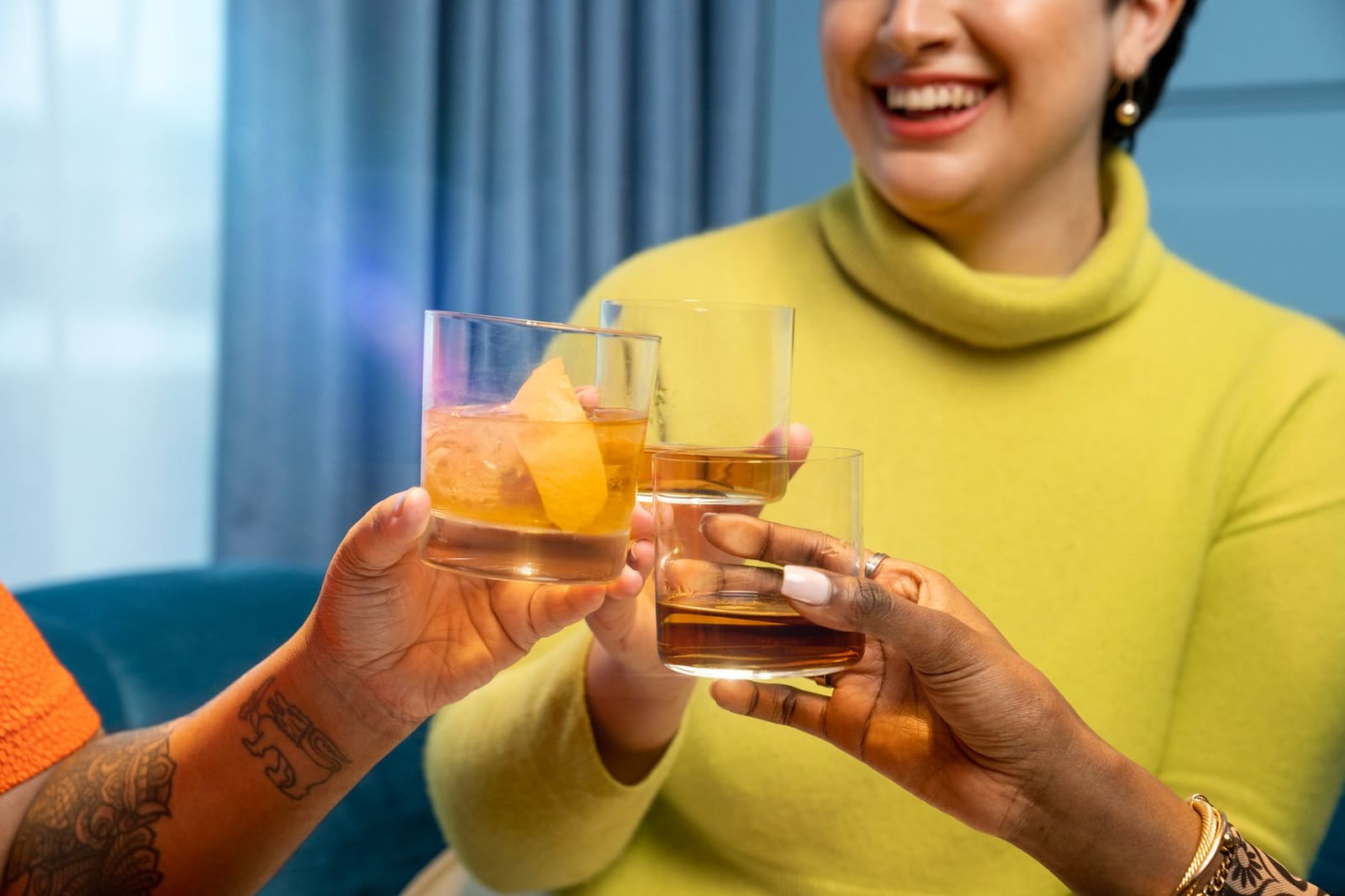 Een Old Fashioned in een tumbler met een grote ijsblok en een schilletje sinaasappel
