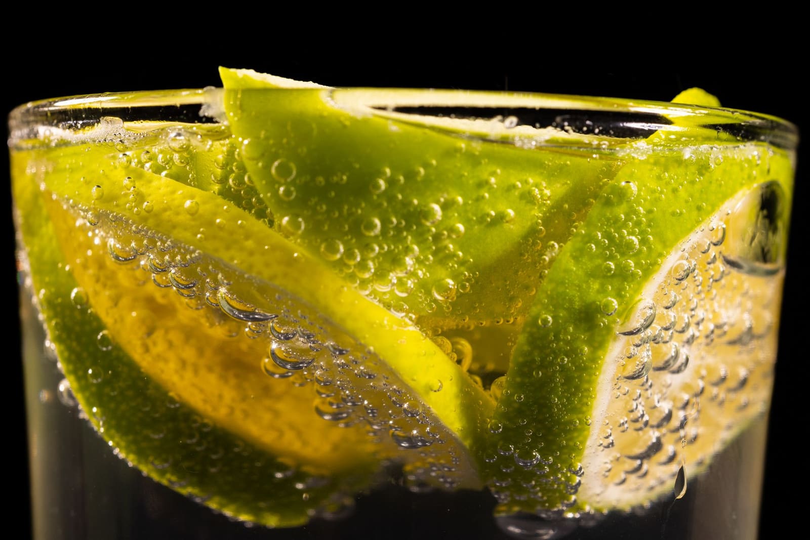 Verse limoenen, suikerstroop en een jigger liggen klaar op een bar voor een klassieke cocktail