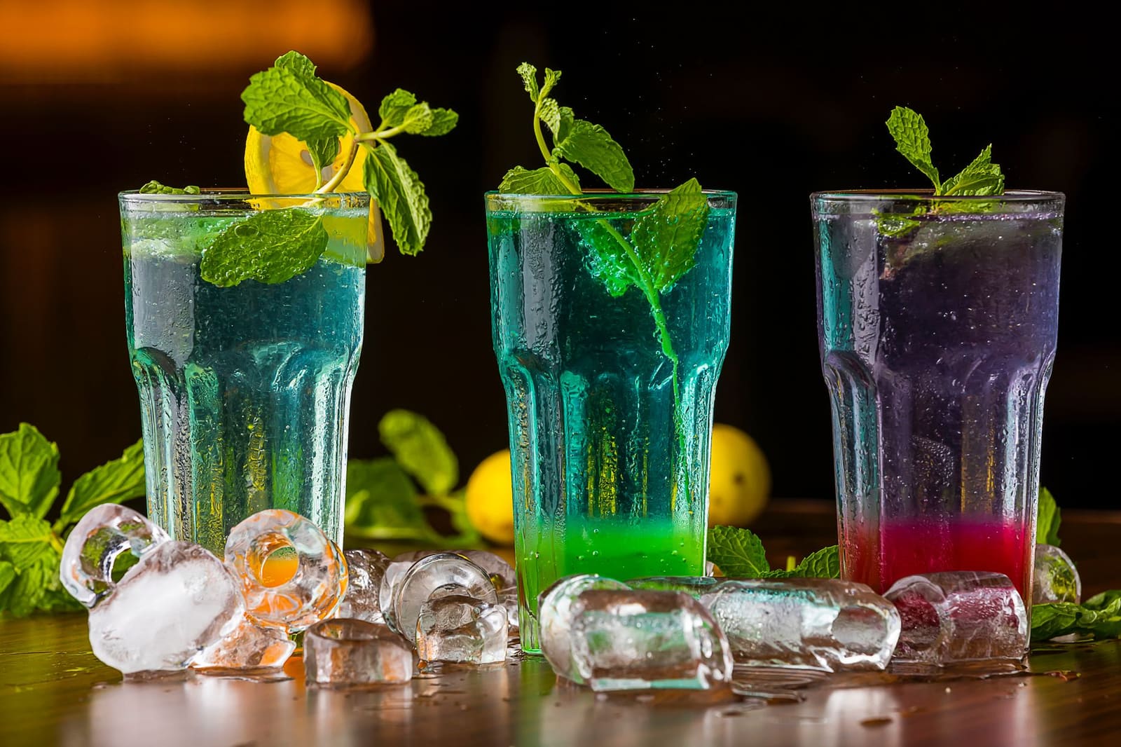 Rij gekleurde cocktails met garnering op een bar