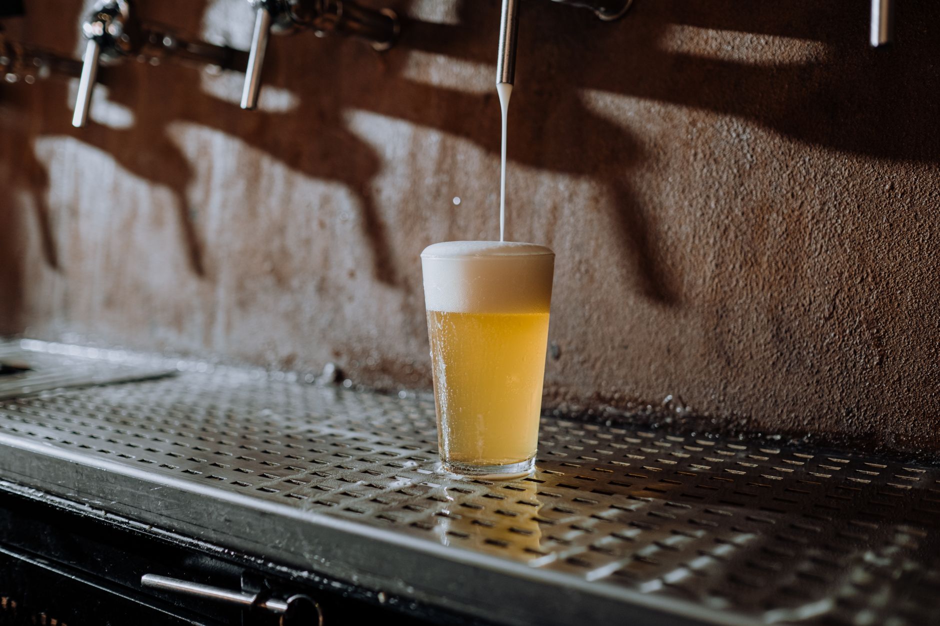 Een glas IPA met stevige schuimkraag op een bar, symbool voor de dominantie van deze bierstijl