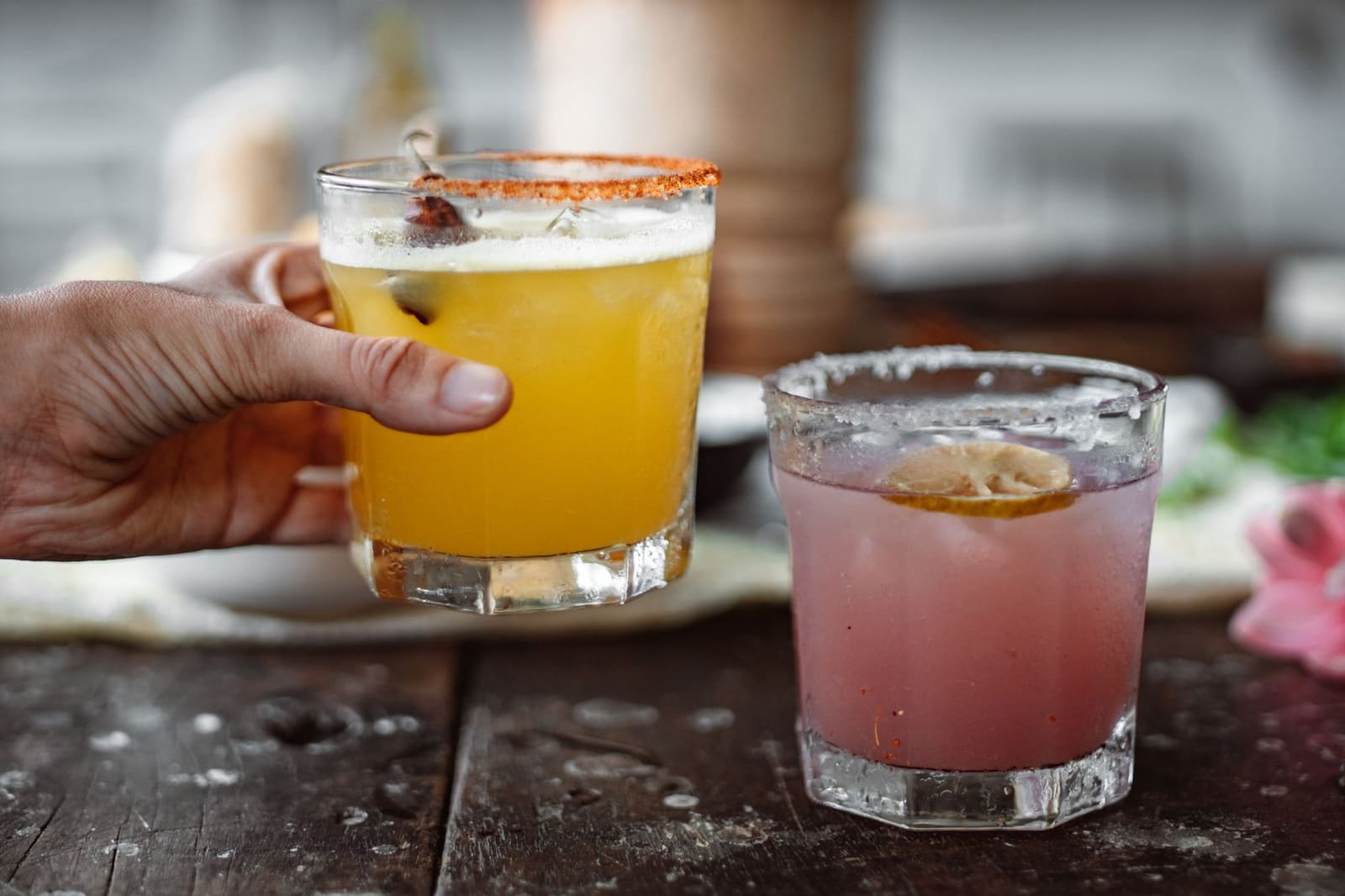 Margarita in een glas met zoutrand en een limoenpartje op een lichte ondergrond.