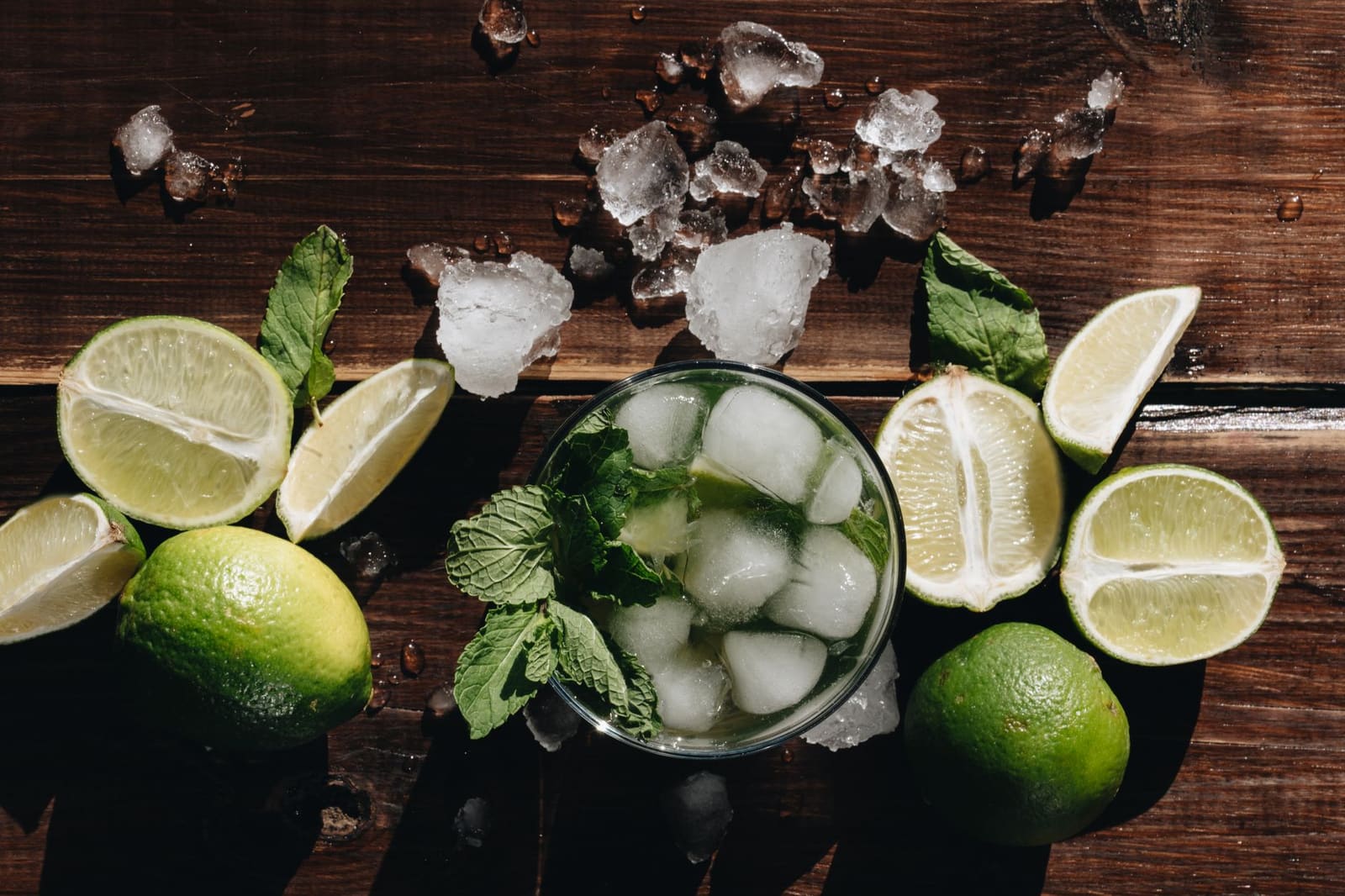 Een mojito met gekneusde munt, limoen en ijs in een hoog glas.