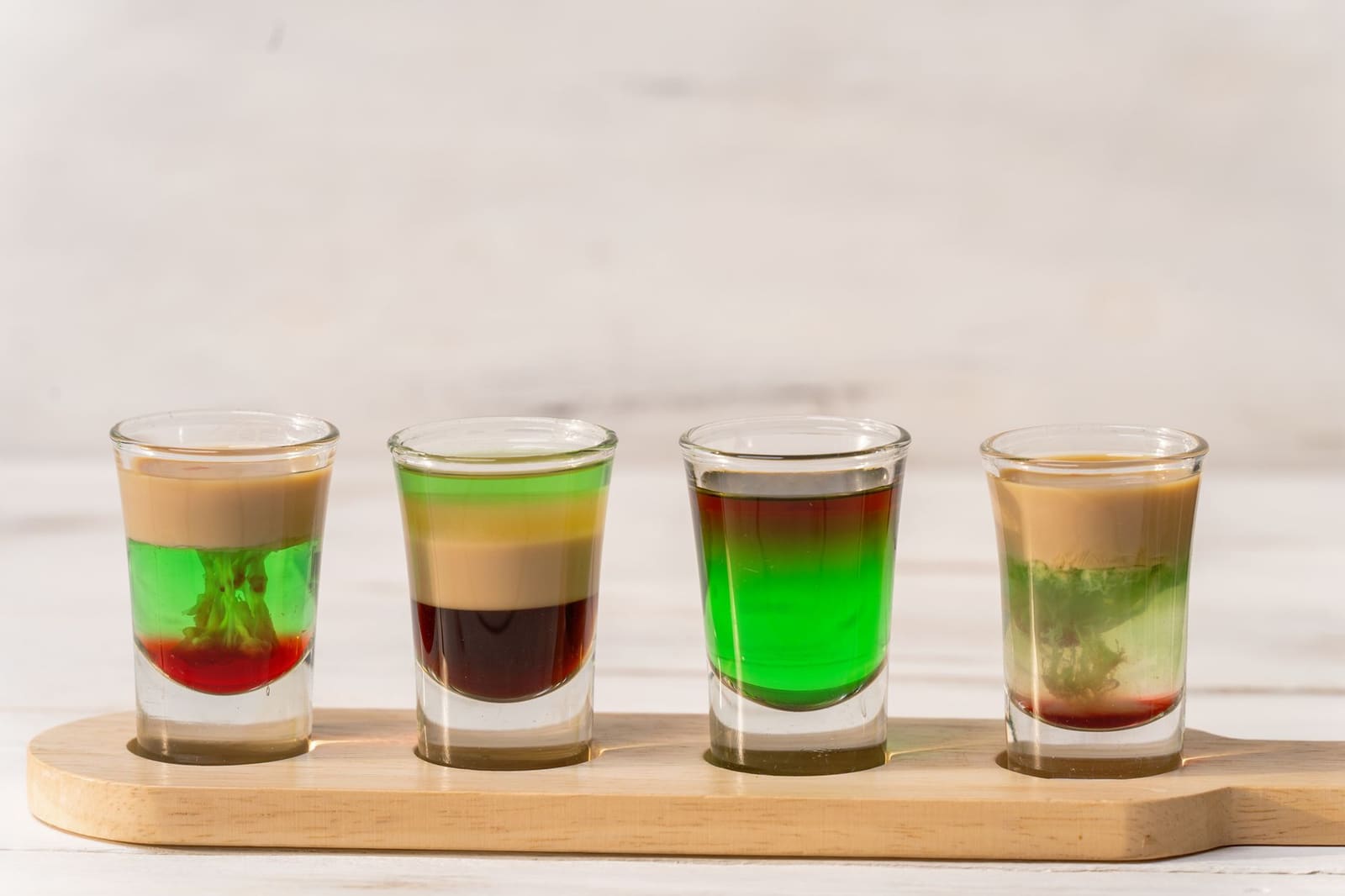 Rij gekleurde cocktails met garnering op een bar