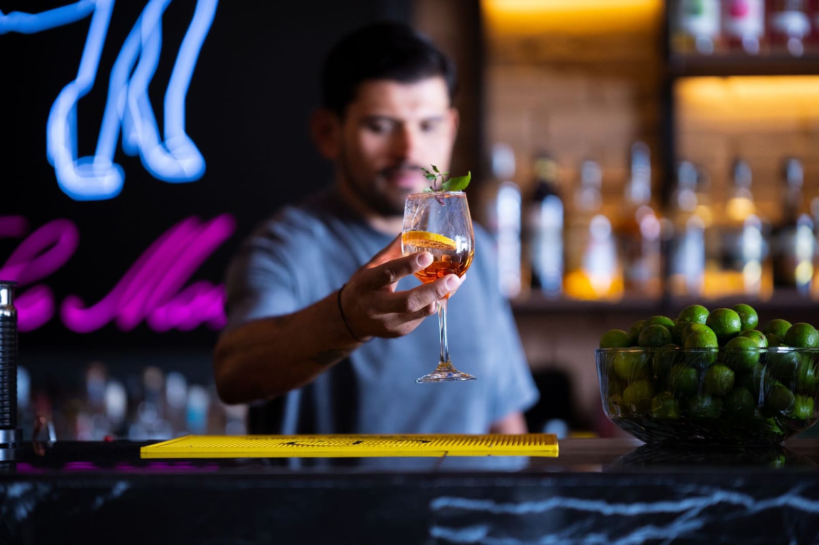 Barman stampt munt en limoen in een glas met een stamper