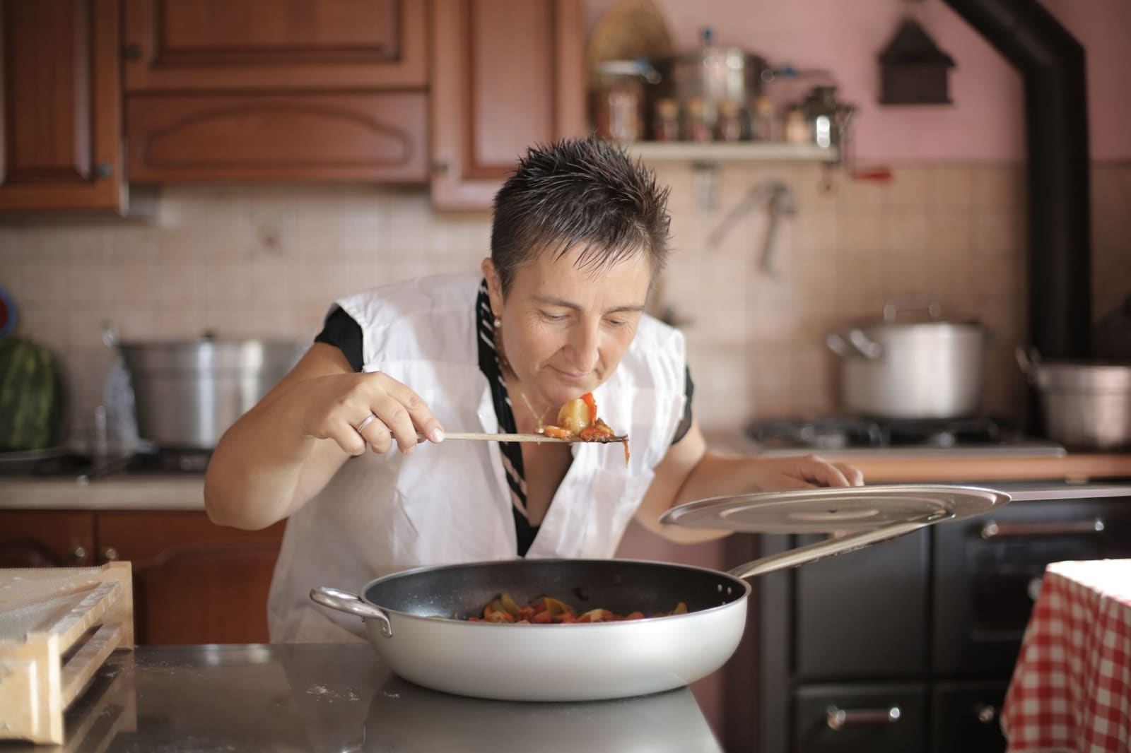 Chef proeft een gerecht in een professionele restaurantkeuken tussen de pannen