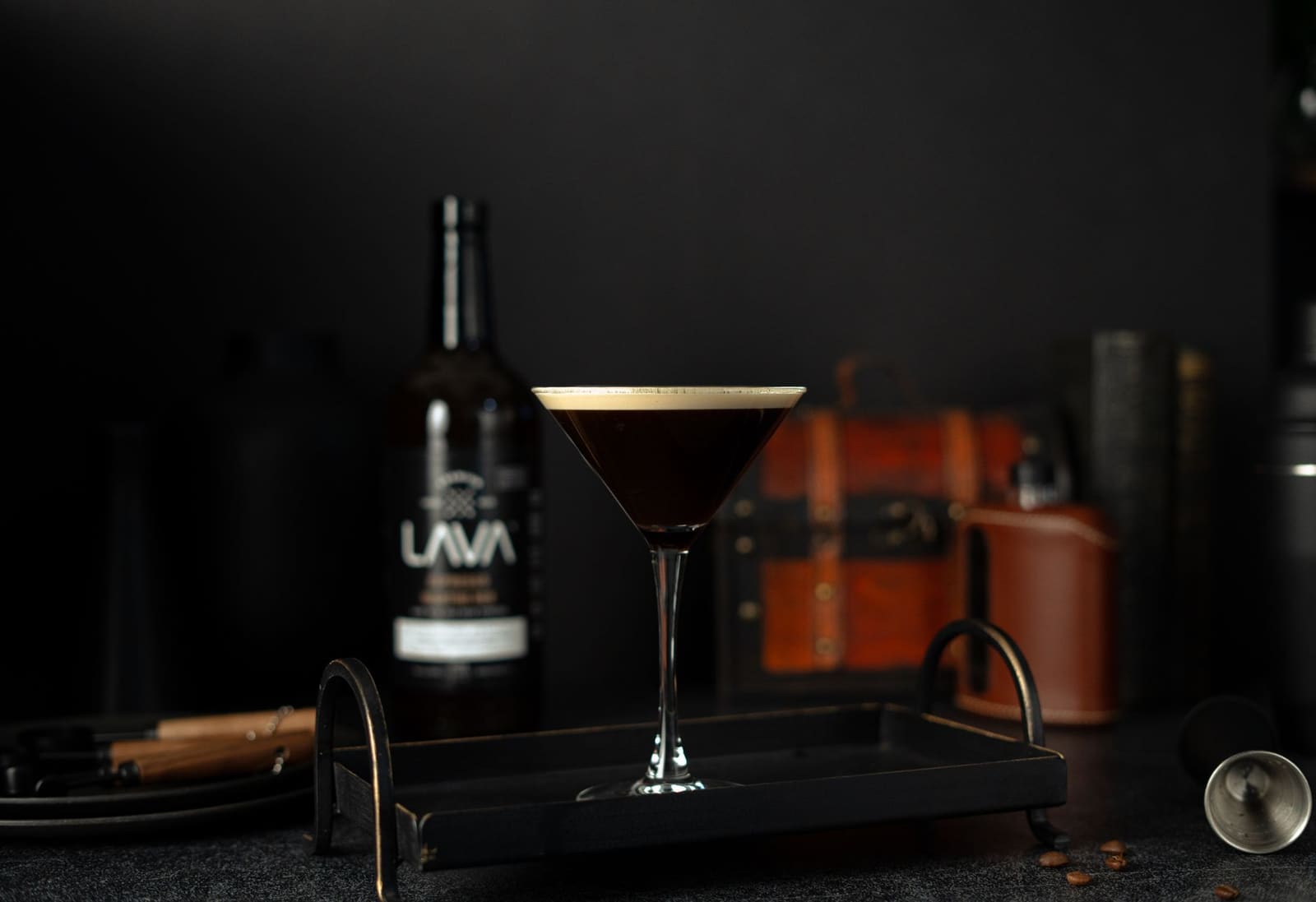 Een espresso martini met koffiebonen als garnering op een donkere bar