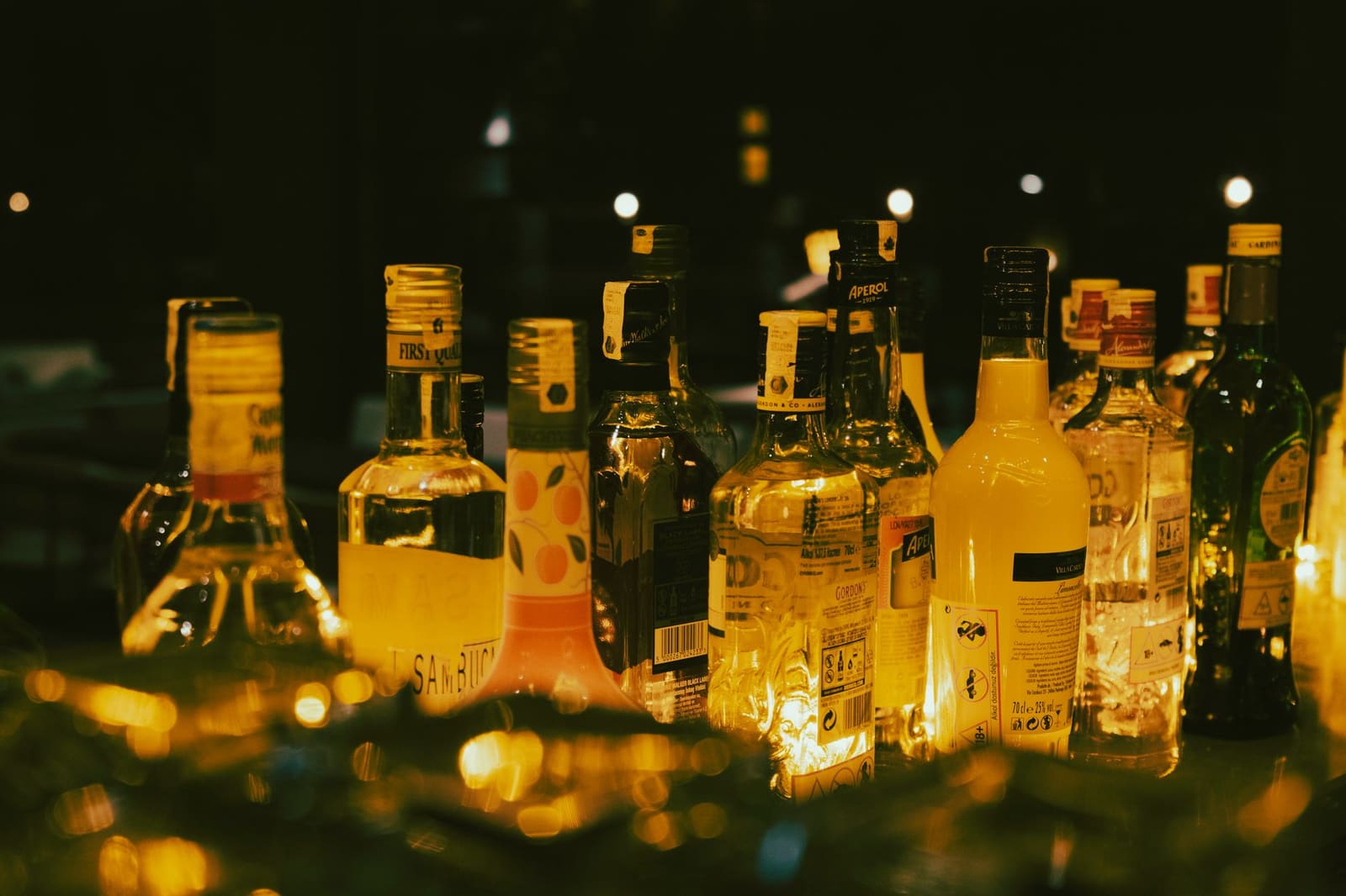 Fles hazelnoot-espresso wodka naast een geshakete koffiecocktail op een donkere bar