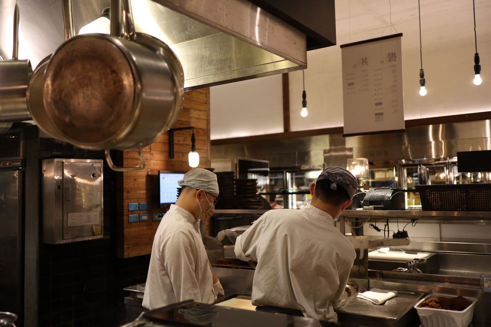 Chef controleert borden op de pass in een drukke restaurantkeuken