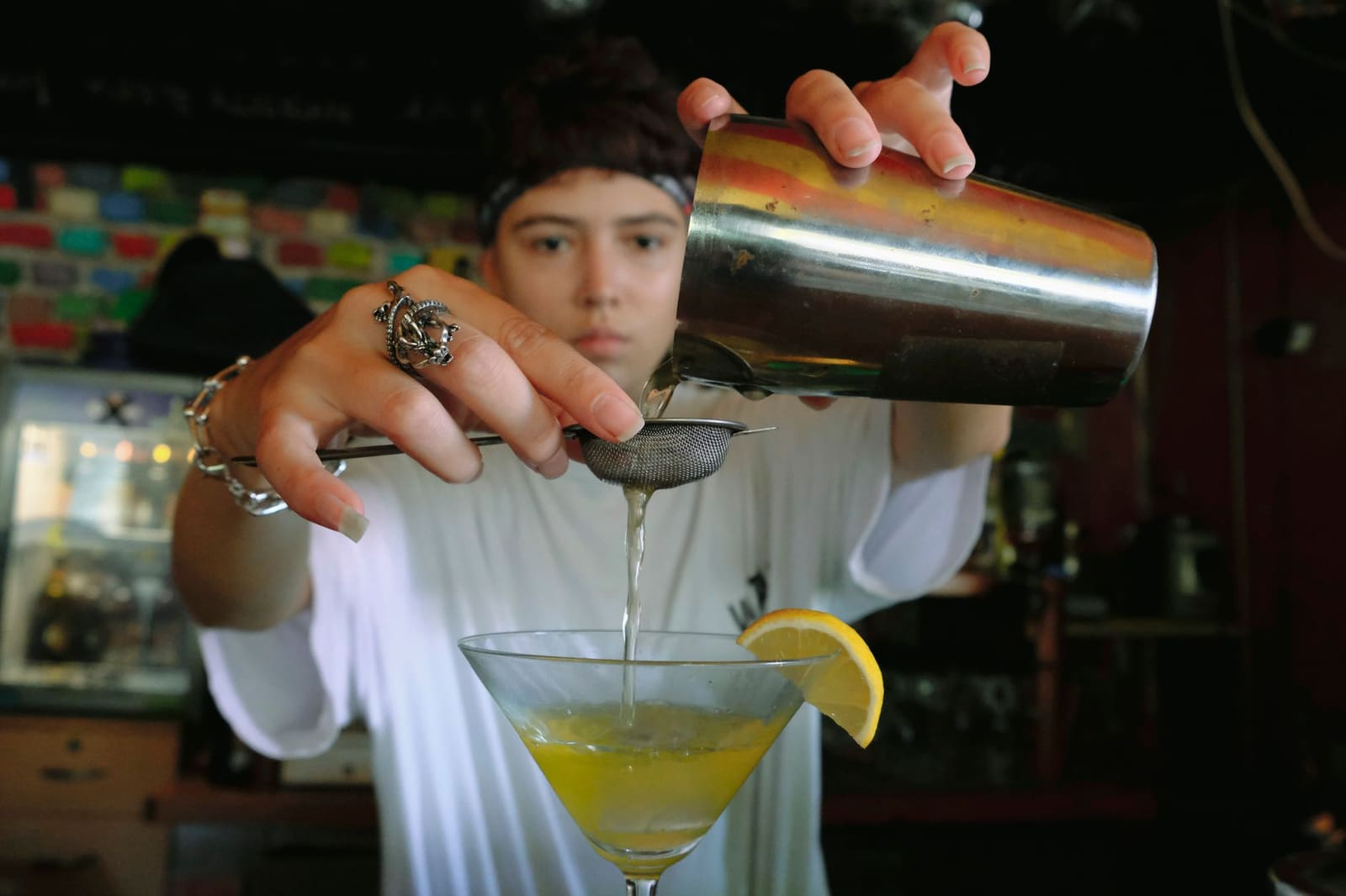 Bartender schenkt een cocktail in aan de bar