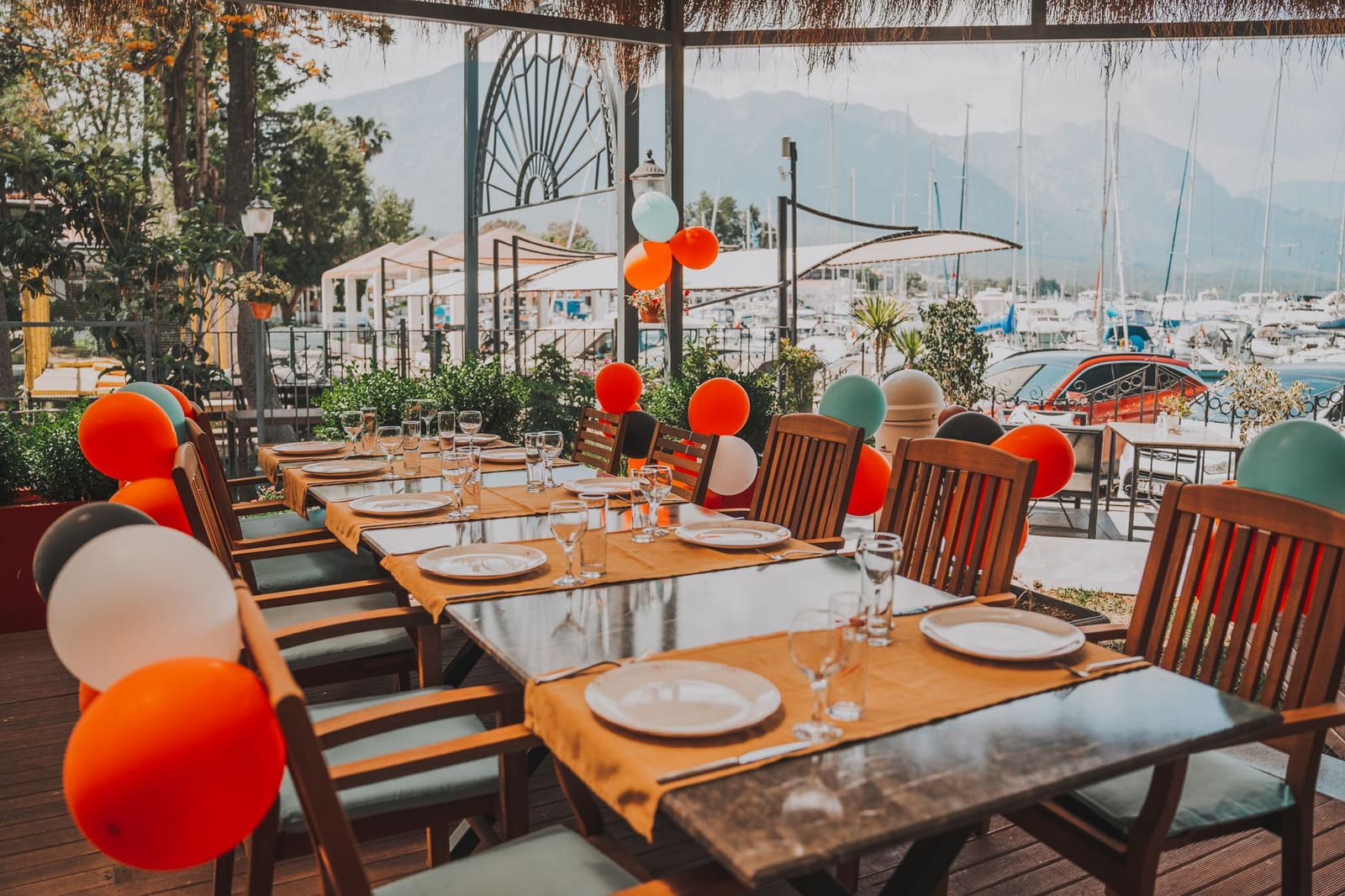 Gezellige terrastafels vol mensen onder parasols in de zomerzon op een plein