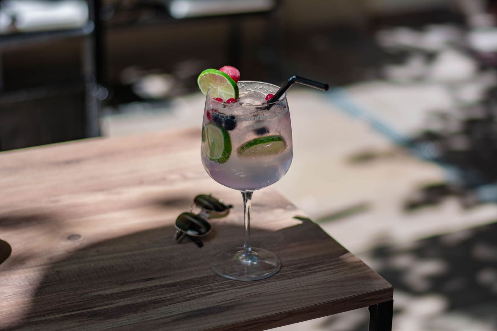 Een gin-tonic in een ruime copa de balón, gevuld met ijs en botanicals op een terras.